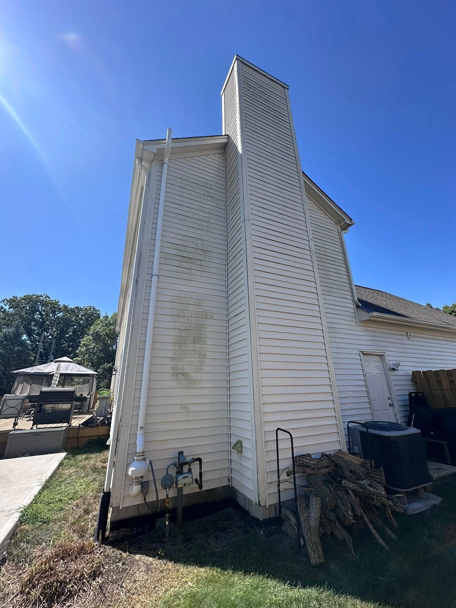 White church exterior with tall steeple and peeling paint under a clear blue sky