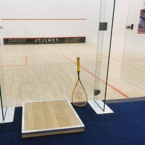 A tilney sign is on the wall of a squash court