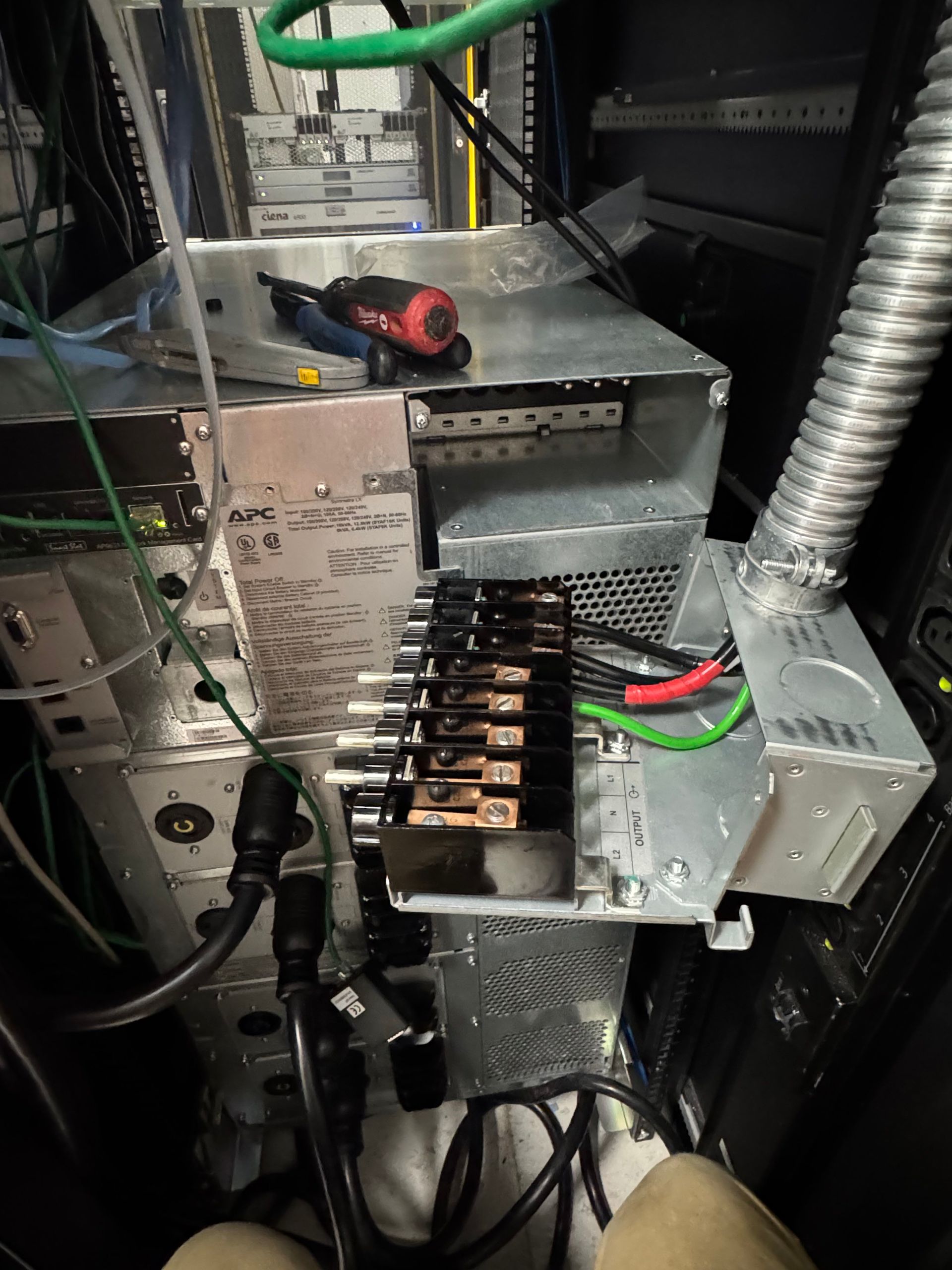 Open electrical panel with circuit breakers, wiring, and a screwdriver inside a metal enclosure.