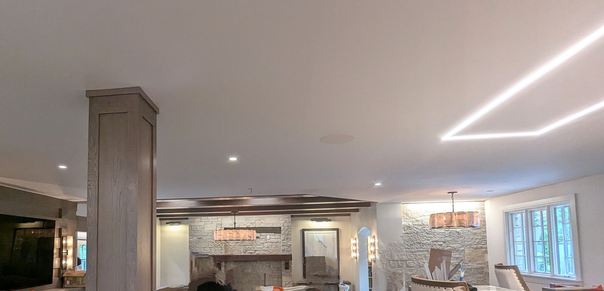 Bright modern lobby with stone fireplace, pillar, recessed lights, and blue-curtained windows