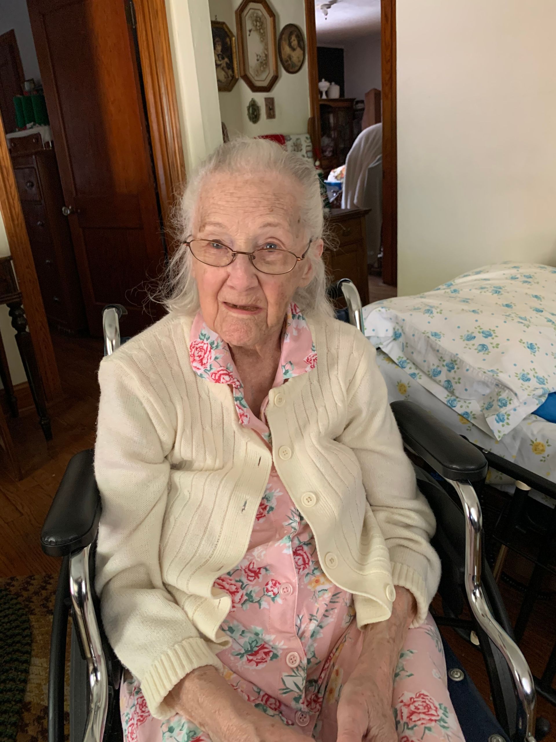 An elderly woman is sitting in a wheelchair in a room.