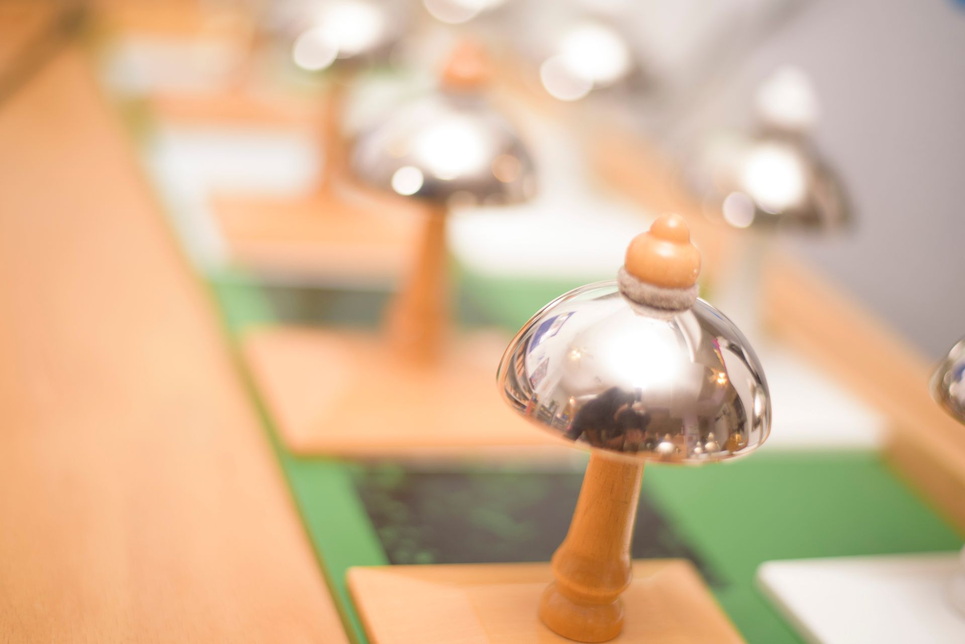 Close-up of a silver-topped wooden bell, with more pieces blurred in the background