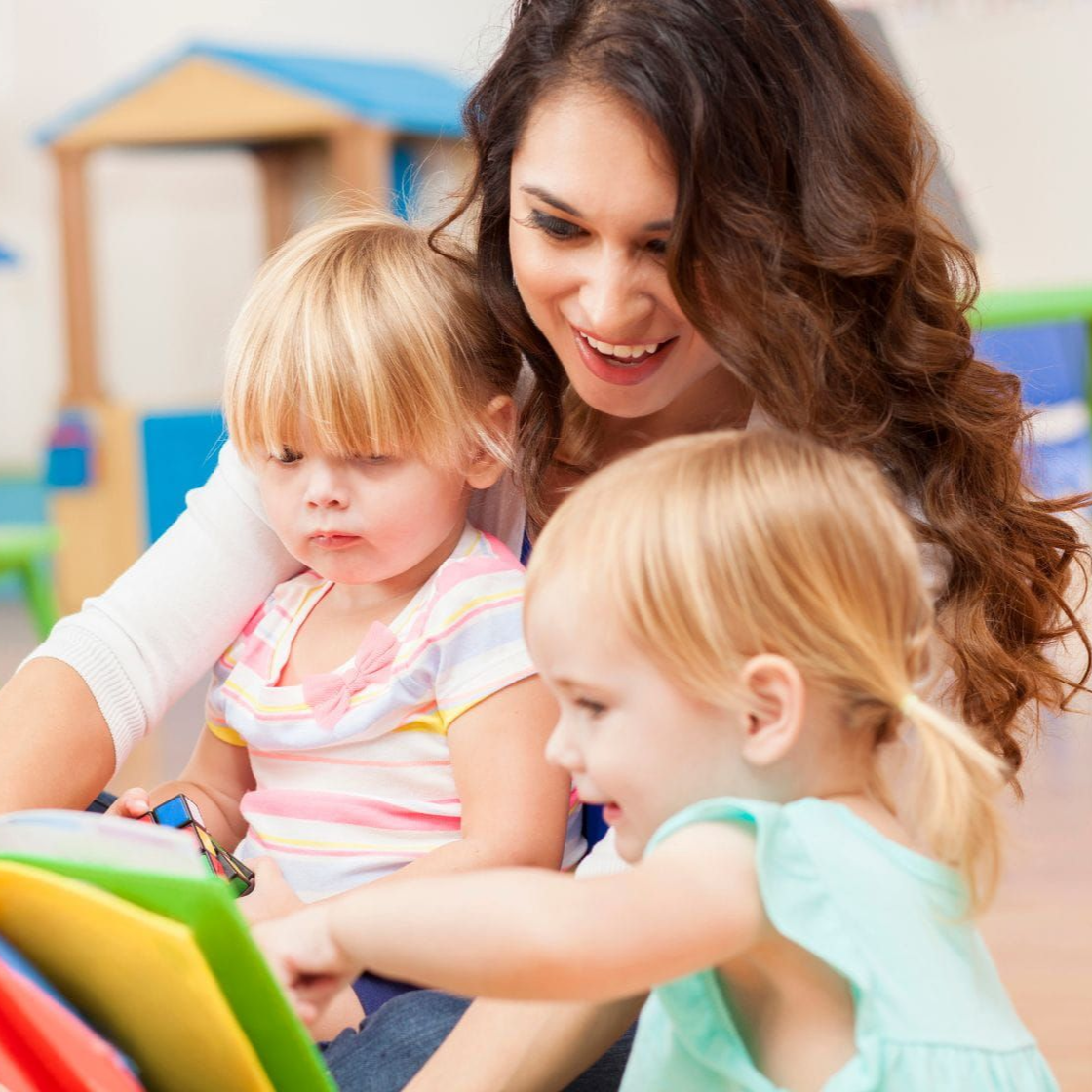 montessori children and teacher reading a book
