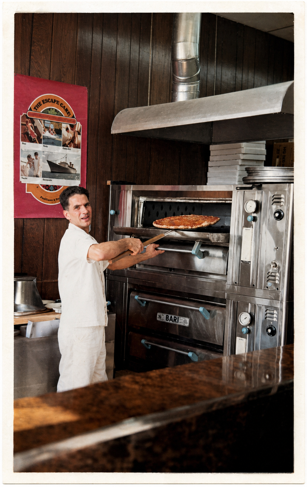 Chef placing a pizza into a wood-fired oven in a restaurant kitchen