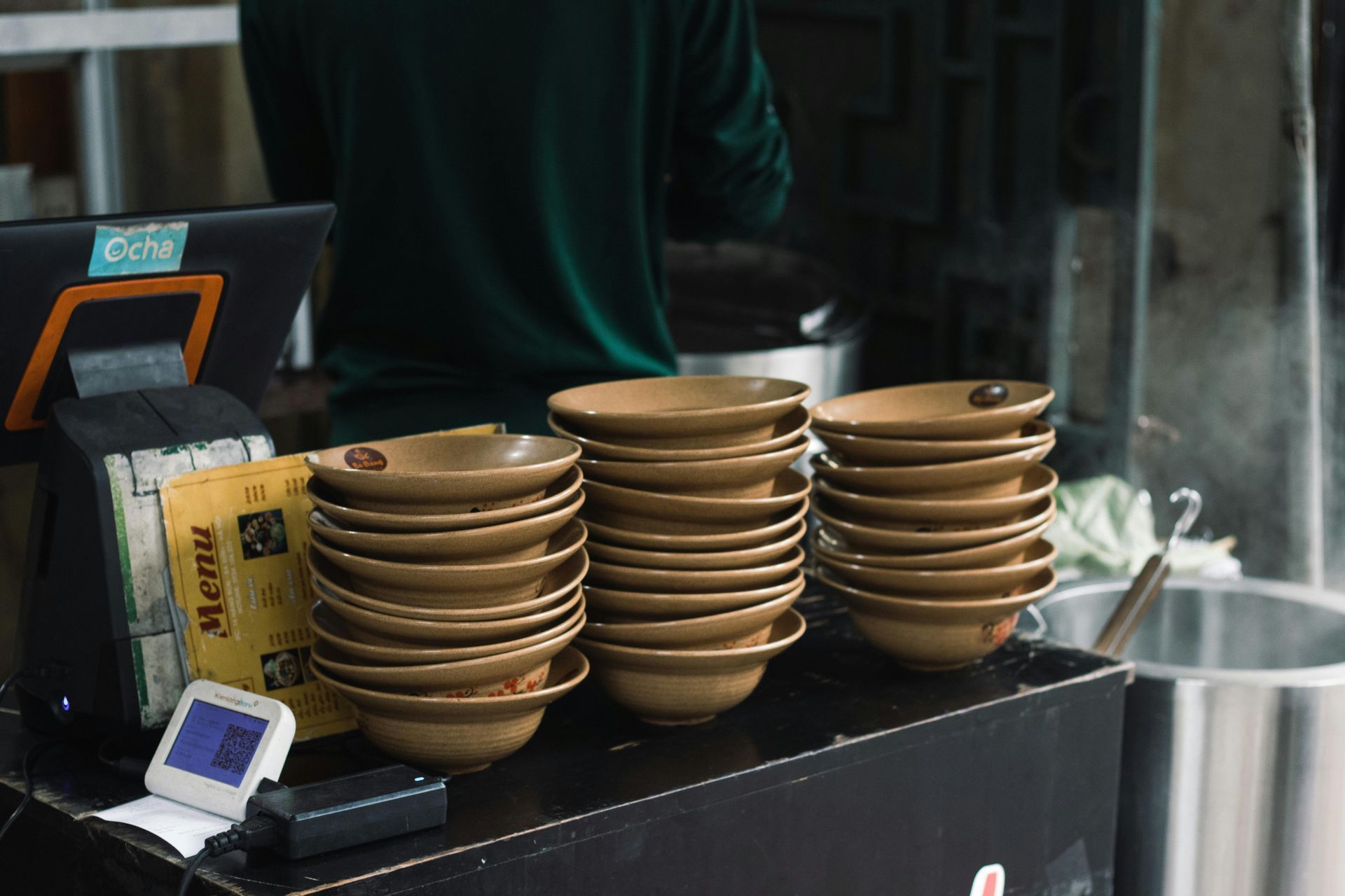 A stack of bowls sitting on top of a counter in a restaurant.