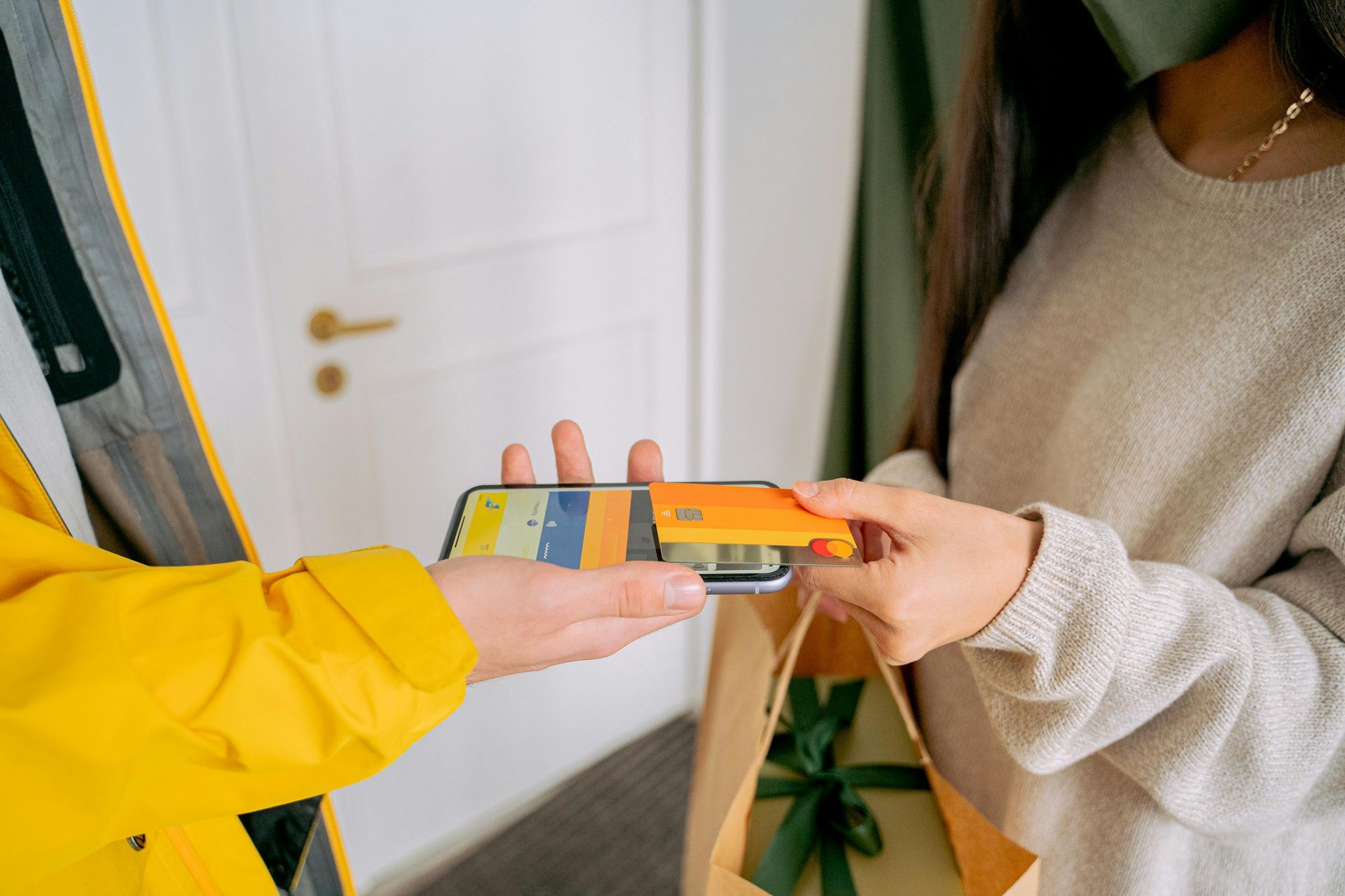 A woman is holding a bag and a cell phone in her hand.