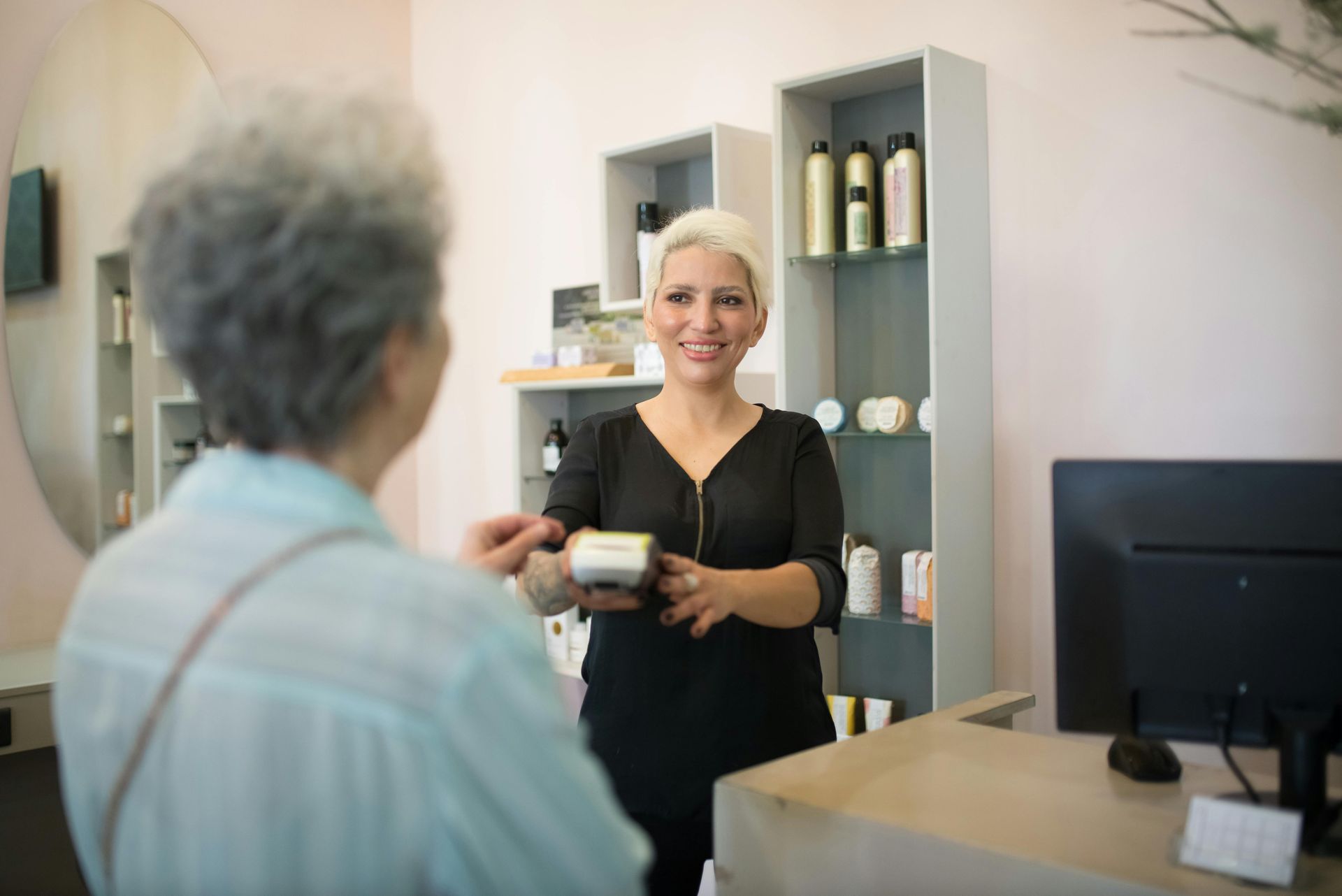 A woman is talking to a customer in a hair salon.