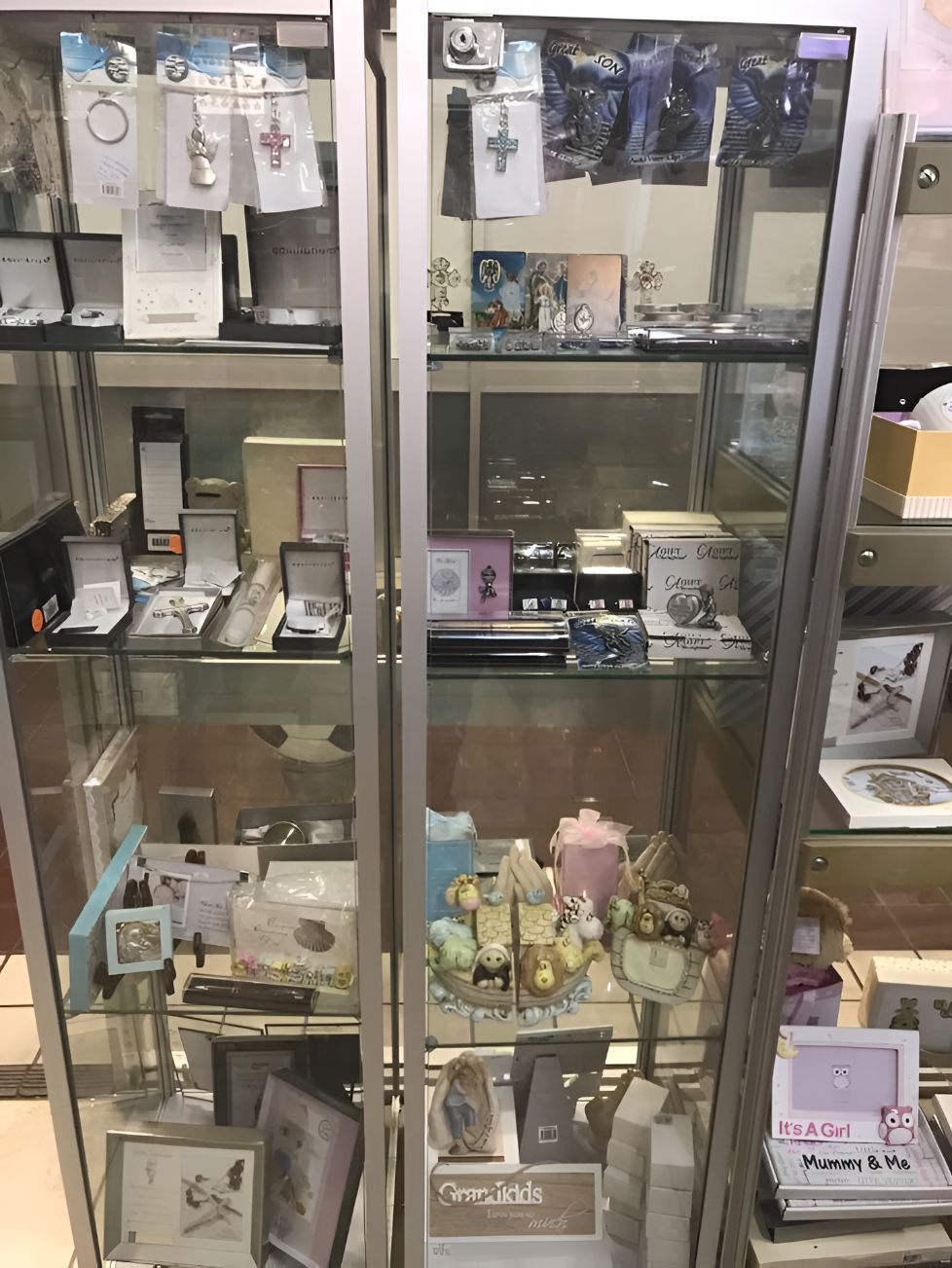 A Glass Display Case Filled With Lots of Jewelry and Other Items — Central West Trophies & Embroidery In Orange, NSW
