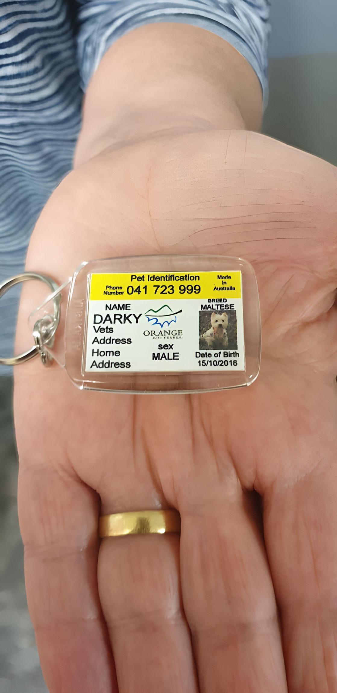 A Person is Holding a Small Keychain in Their Hand — Central West Trophies & Embroidery In Orange, NSW