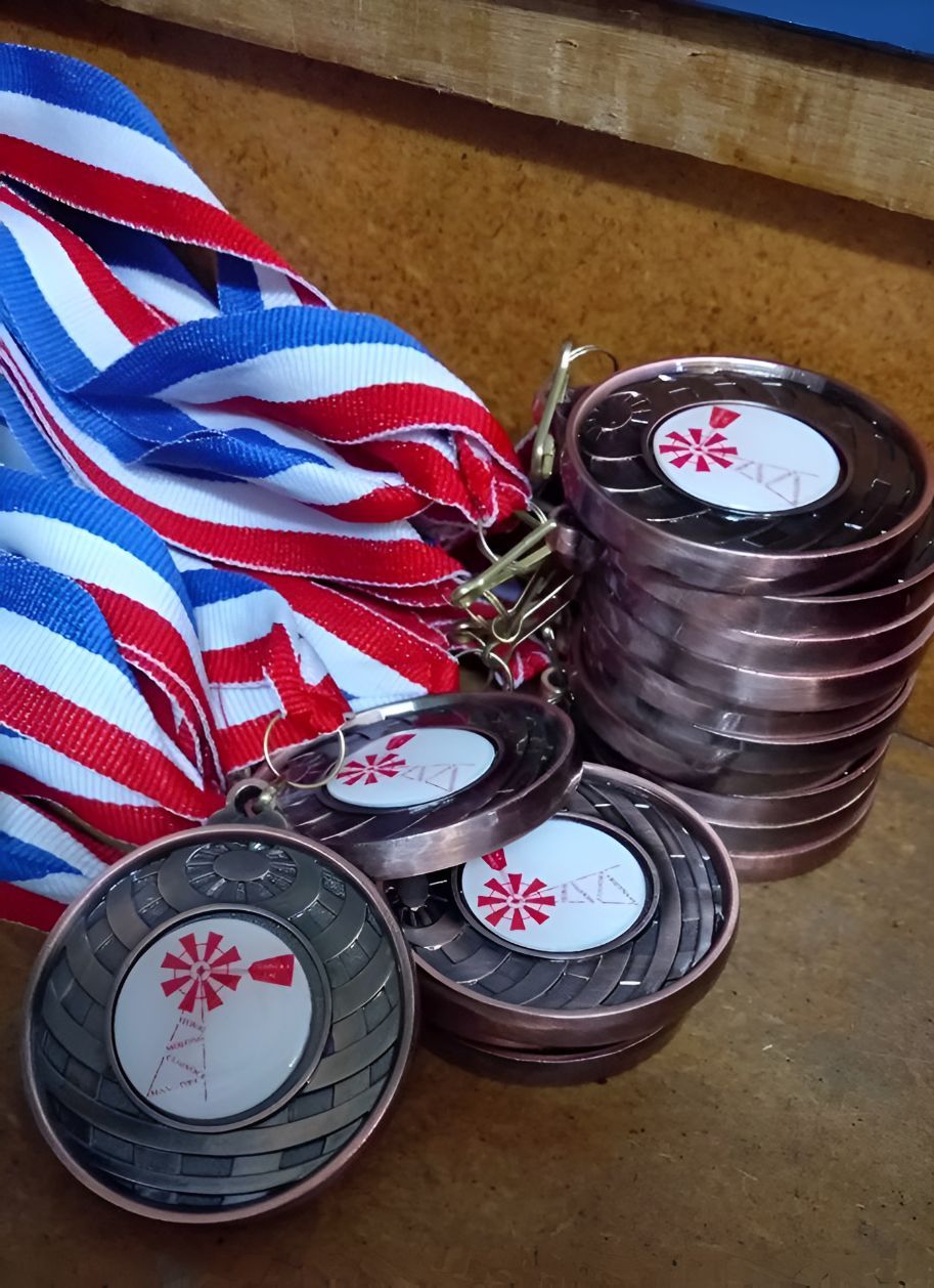 A Bunch of Medals Are Stacked on Top of Each Other — Central West Trophies & Embroidery In Orange, NSW