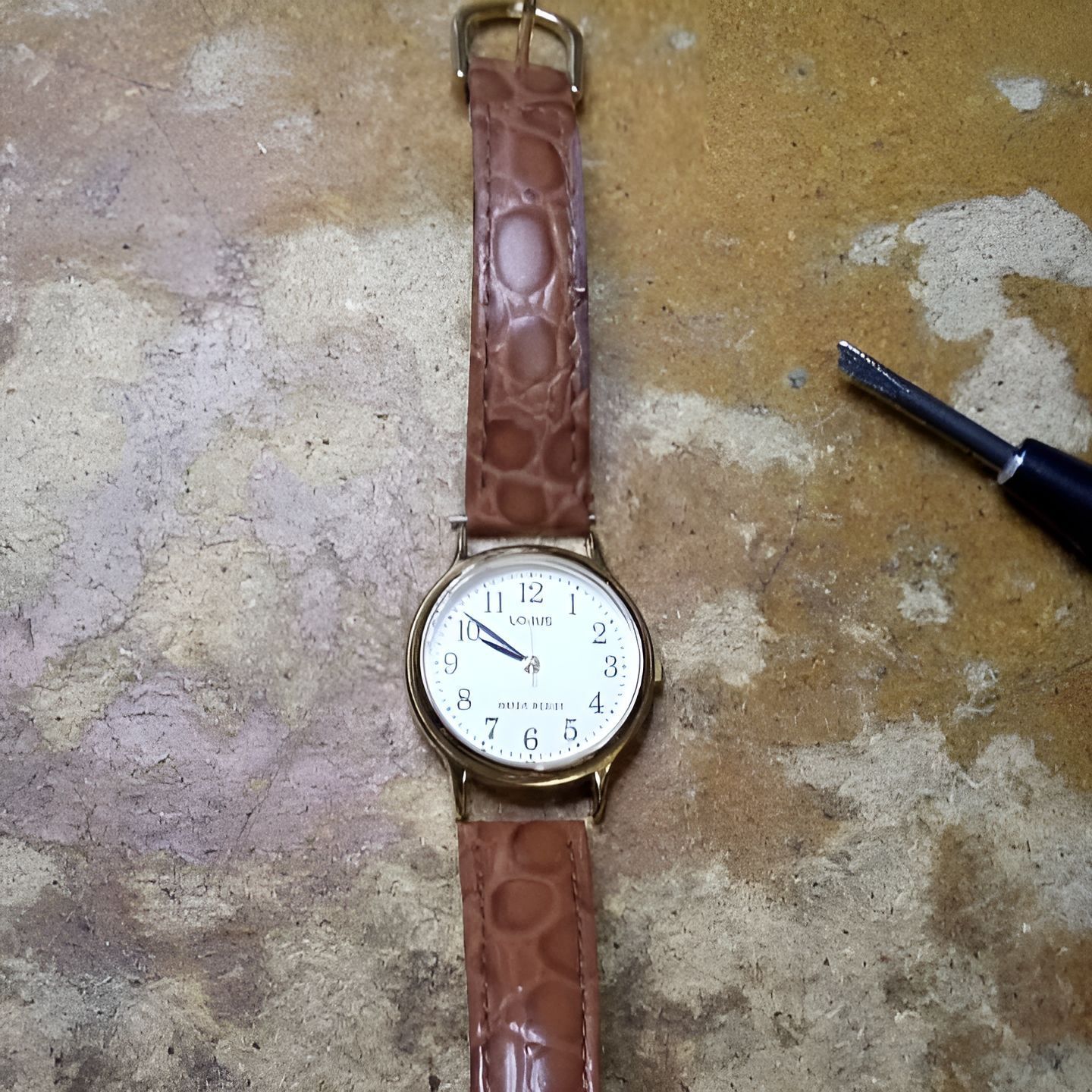 A Watch With a Brown Leather Band is Laying on a Table — Central West Trophies & Embroidery In Orange, NSW