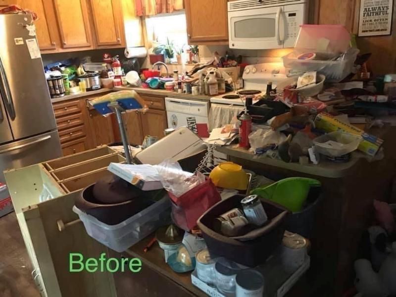 Cluttered kitchen with appliances, overflowing counters, and various objects scattered around.