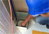 Un hombre que lleva un casco azul está trabajando en una caja.