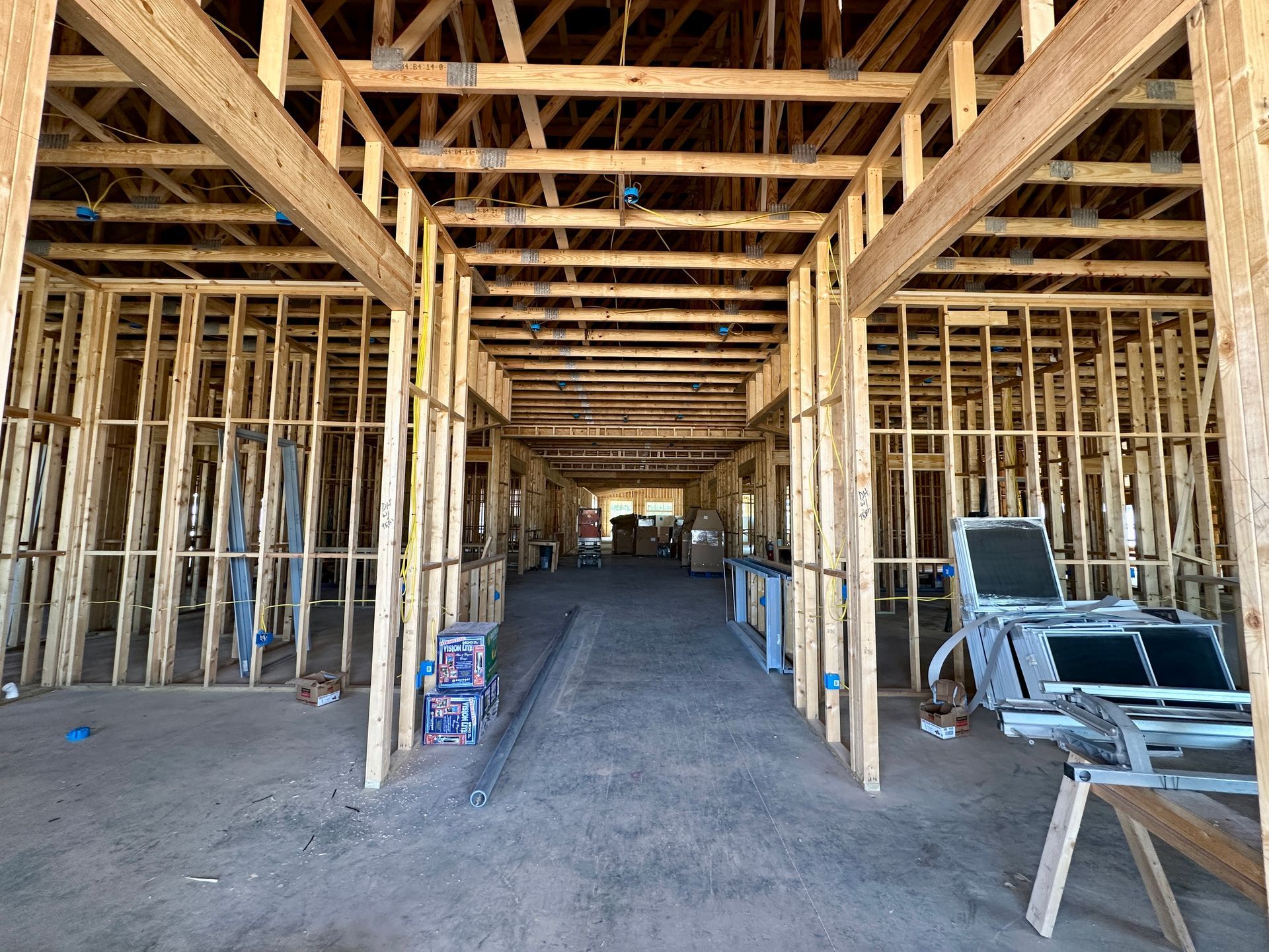 Interior of a building under construction, showcasing wooden framing and an open corridor.