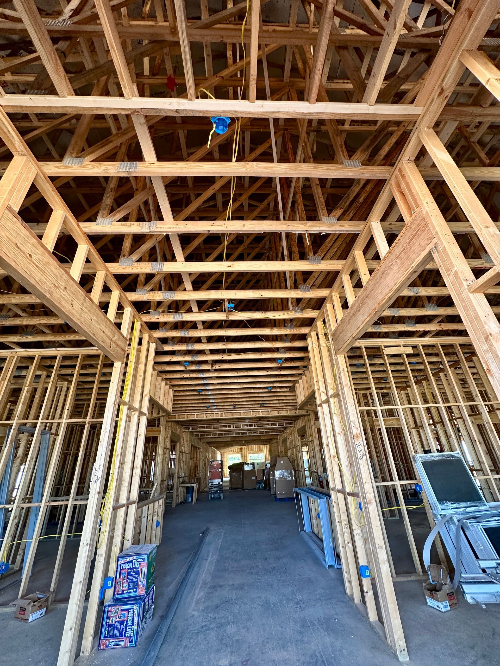 Interior view of a building under construction, showing exposed wooden framing, and the unfinished ceiling.