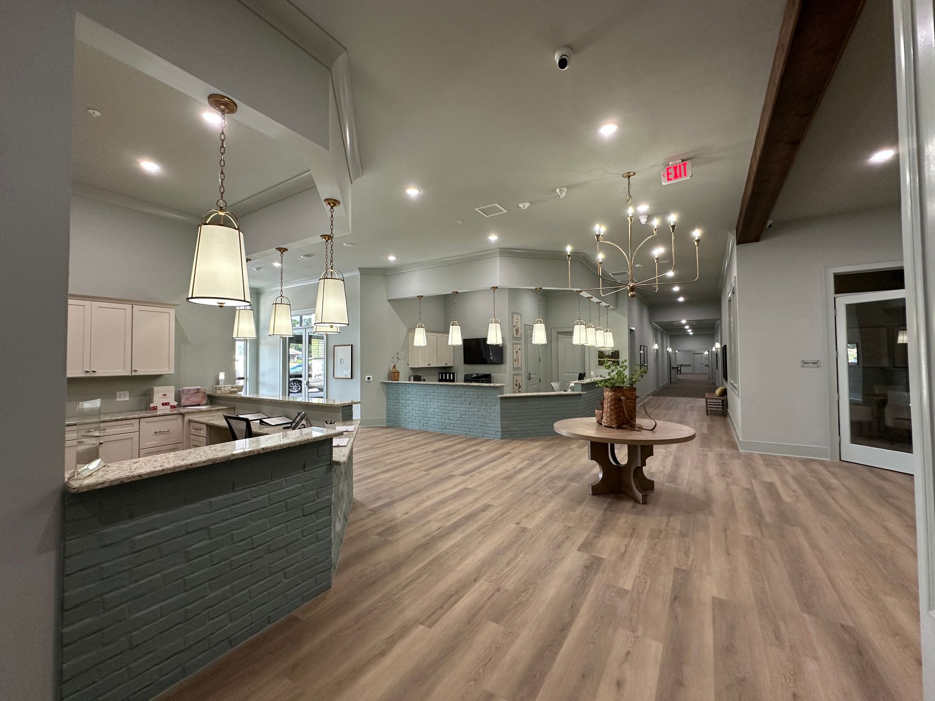 Bright modern café interior with wood floors, pendant lights, and a central display table