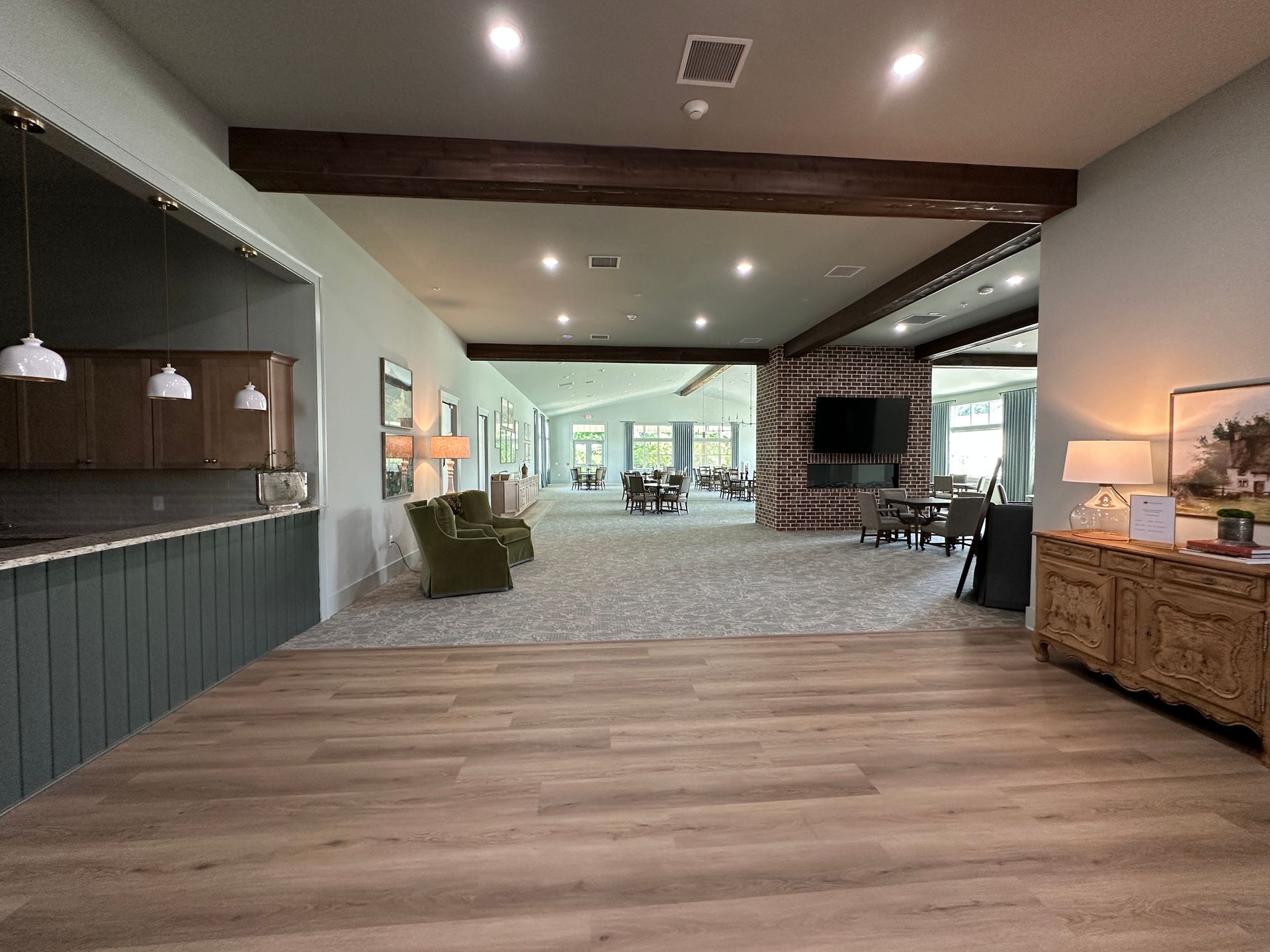 Modern hotel lobby with wood floors, exposed beams, seating area, and reception desk