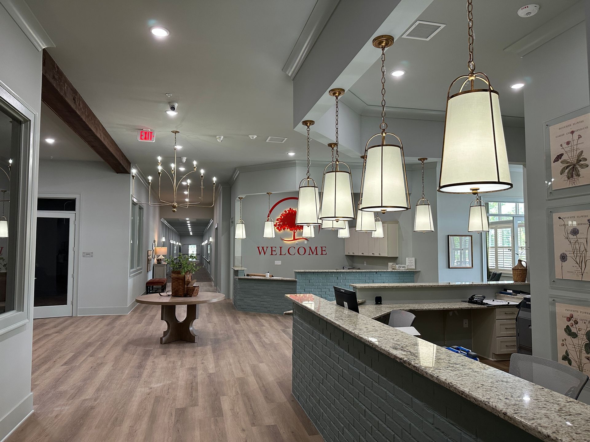 Bright modern lobby with pendant lights, wood floors, and a reception desk