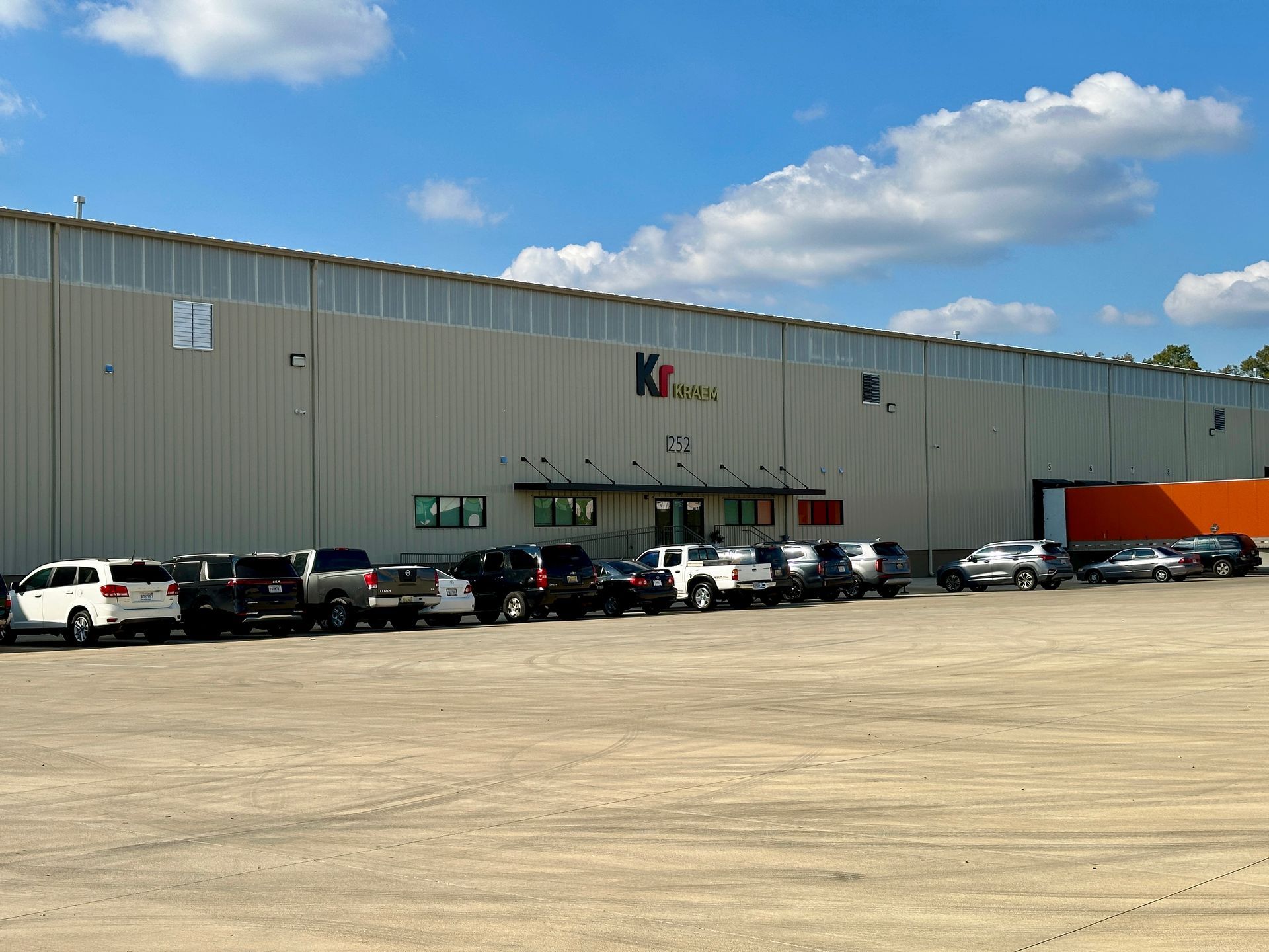 A large building with a lot of cars parked in front of it.