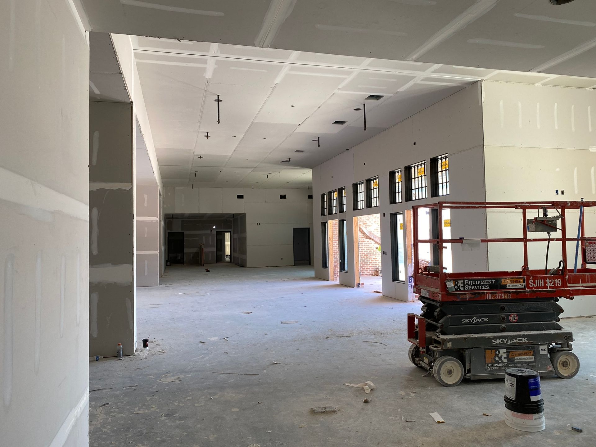 A large empty room with a scissor lift in the middle