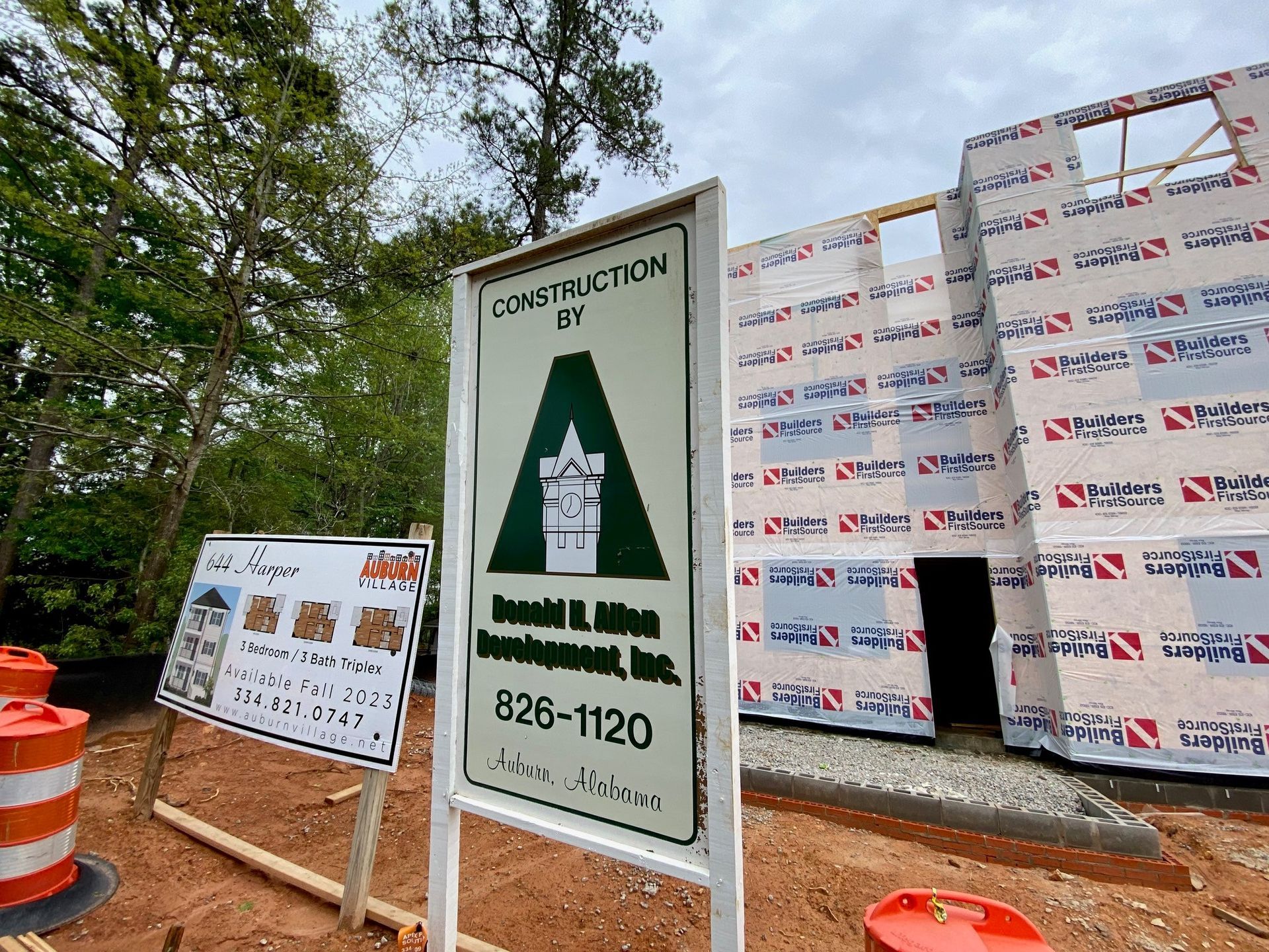 A construction sign is sitting in front of a building under construction.