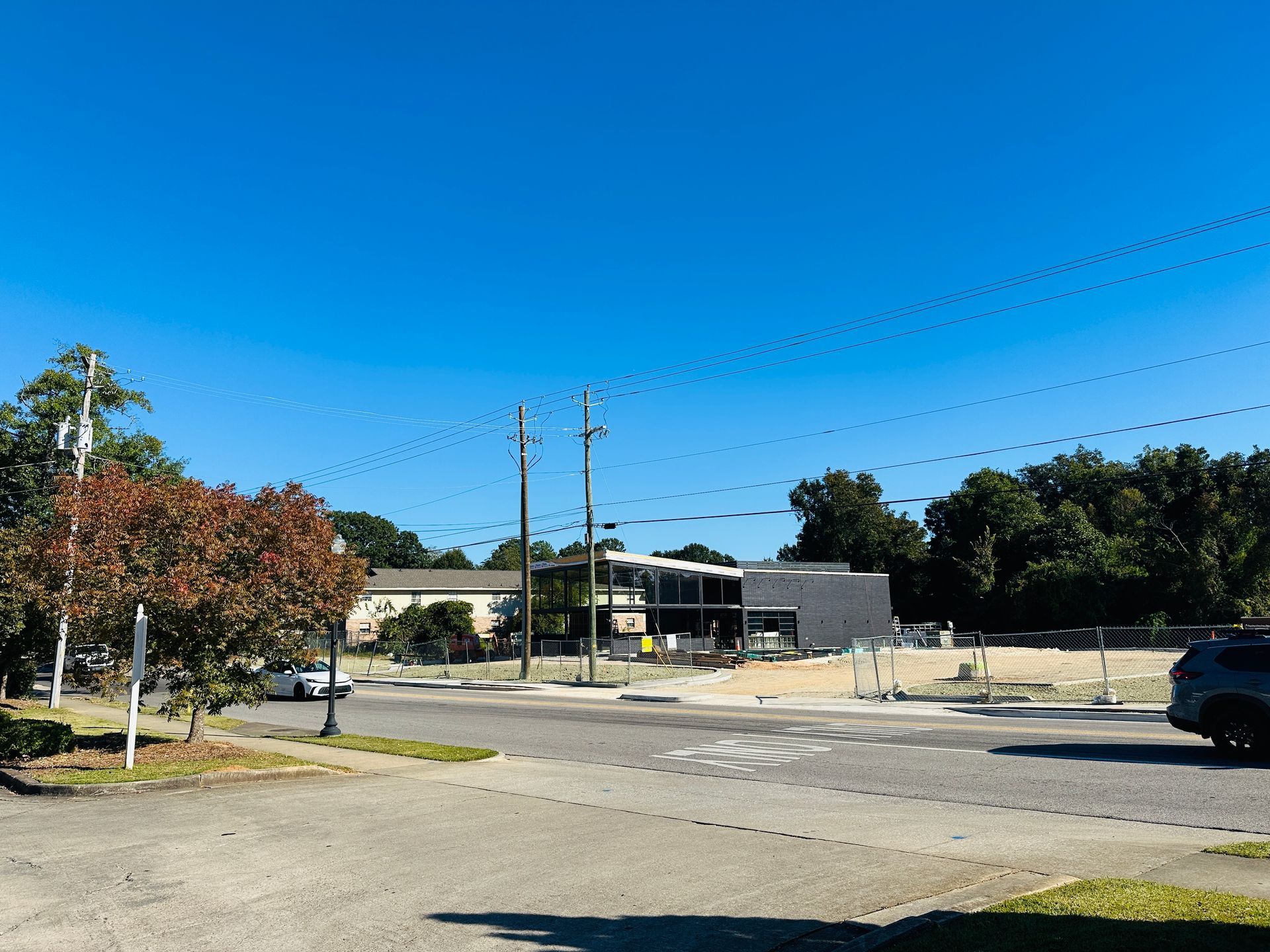 Quiet parking lot and low buildings under a clear blue sky on a sunny day