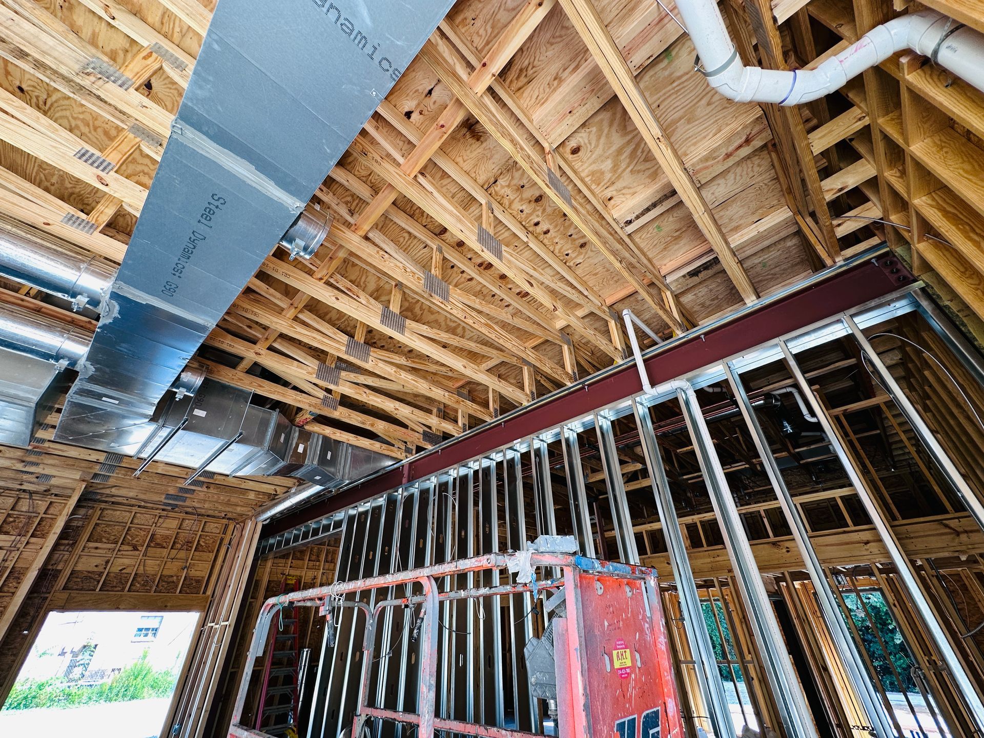 Exposed wood framing and ductwork in an unfinished house under construction