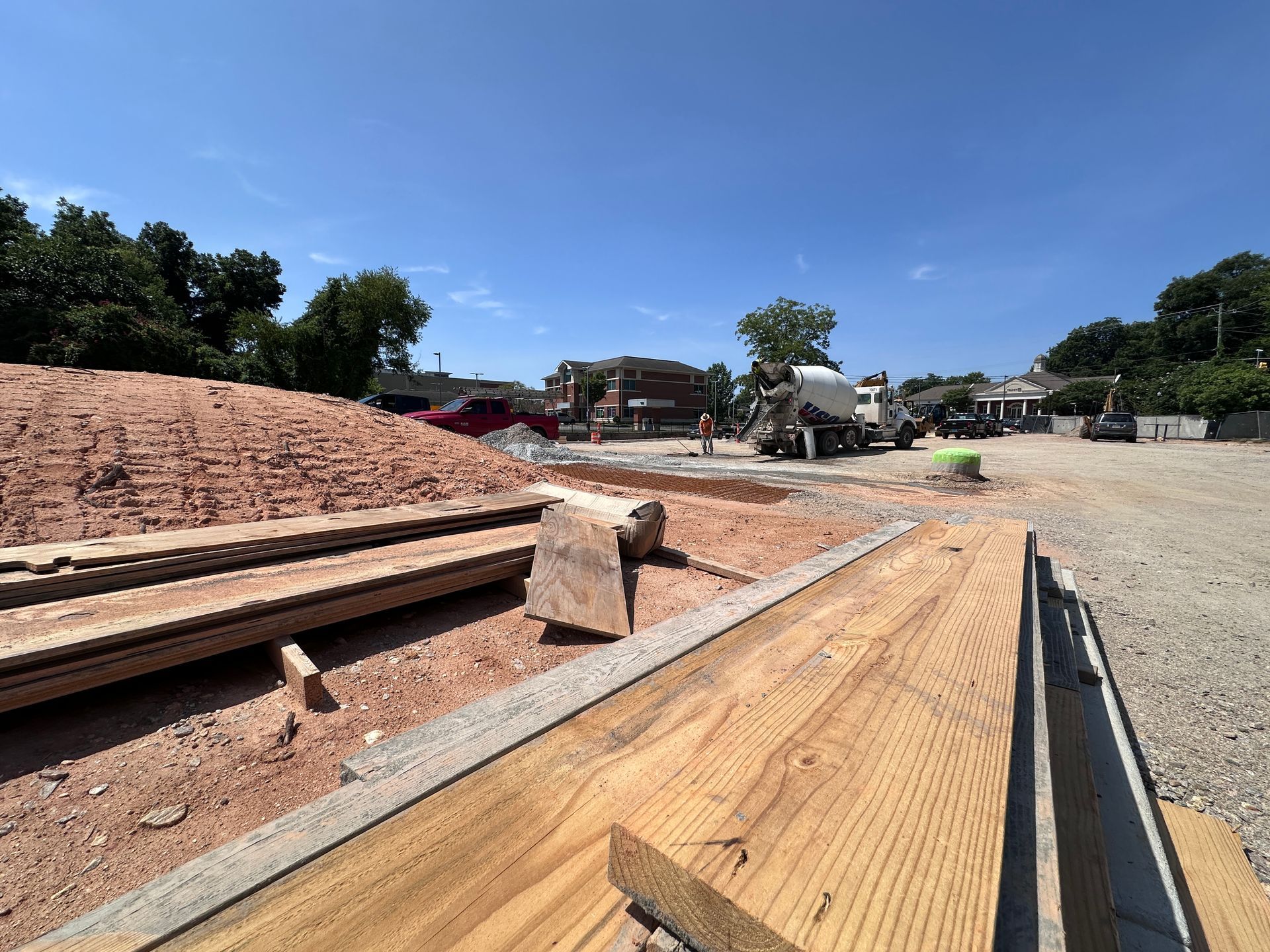 Construction site with wooden ramps and dirt embankments under a clear blue sky