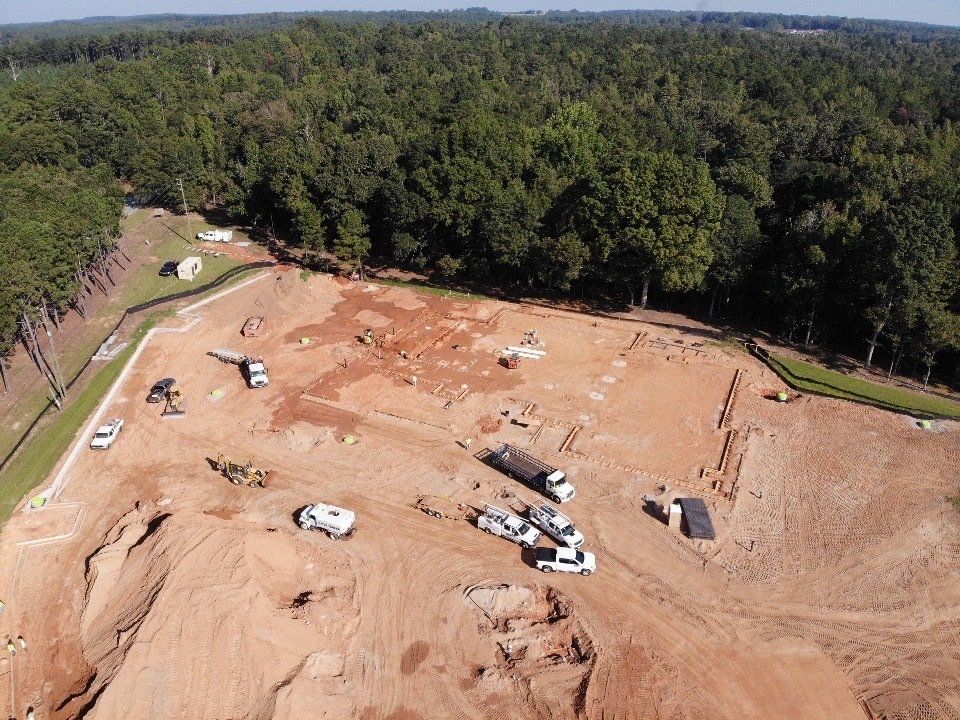 An aerial view of a construction site in the middle of a forest.