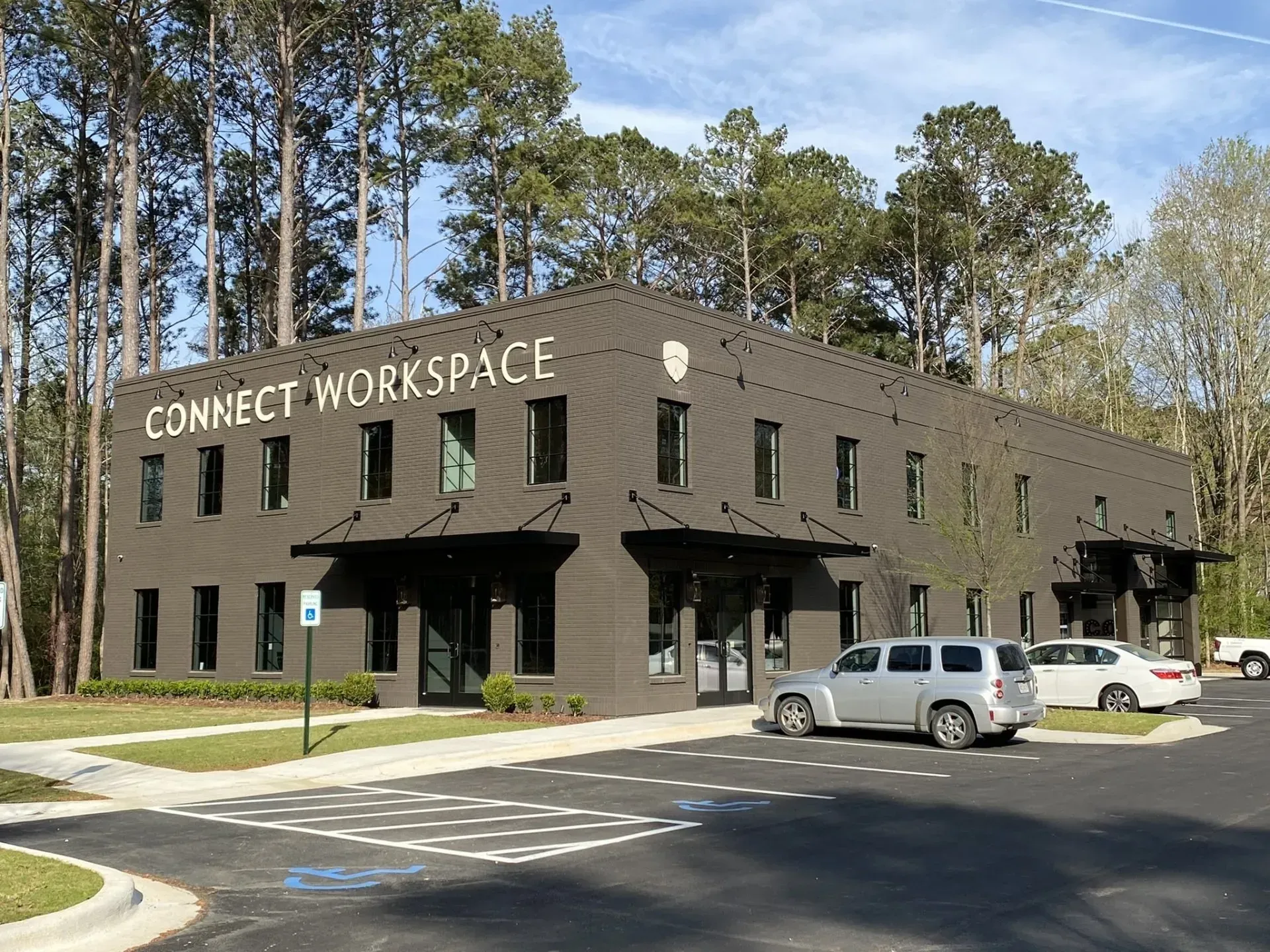Connect Workspace building with parked cars, dark brick exterior, and trees outside