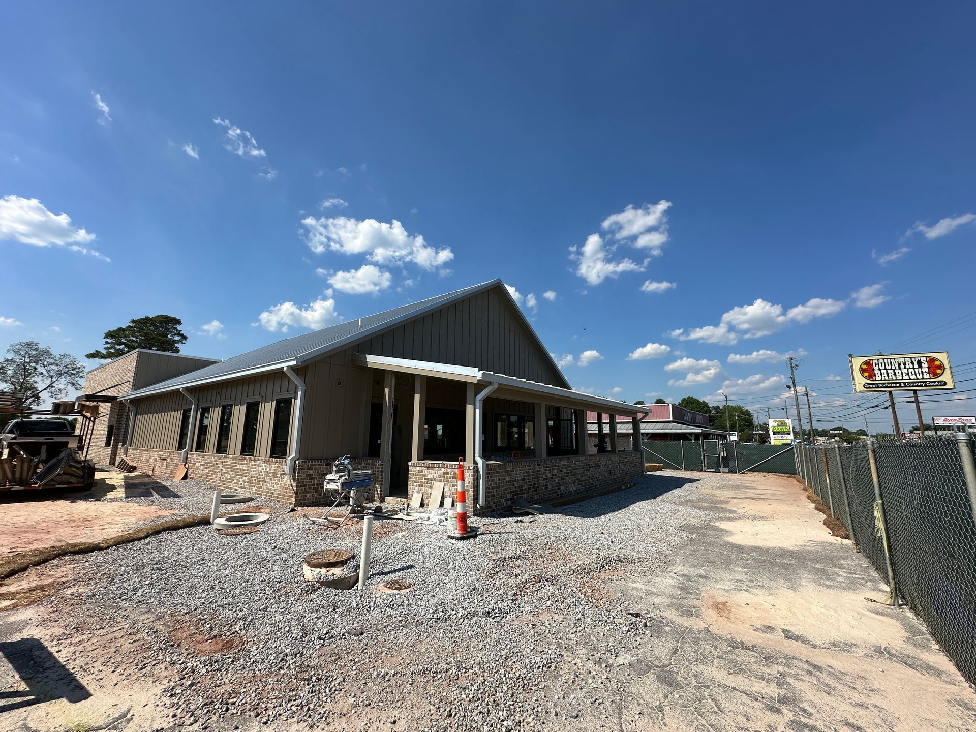 A building is being built next to a gravel road.