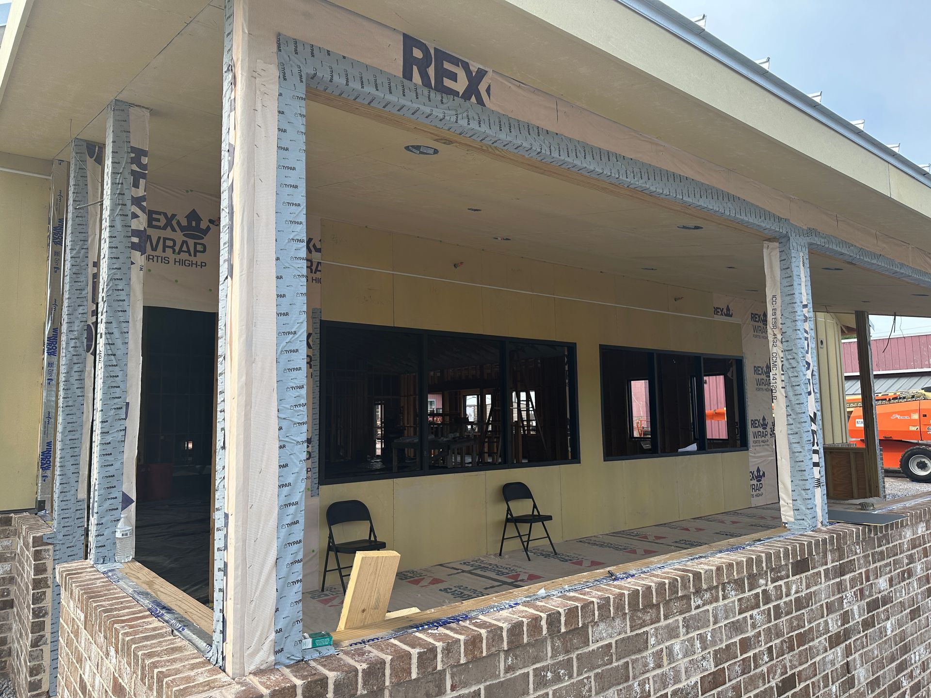 A building under construction with a sign that says rex on it