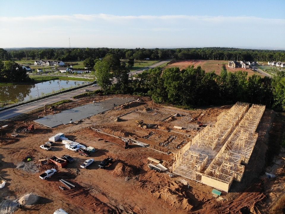 An aerial view of a construction site with trees in the background