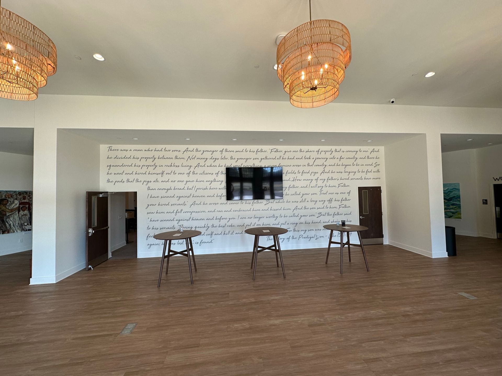 A large room with tables and a television on the wall.