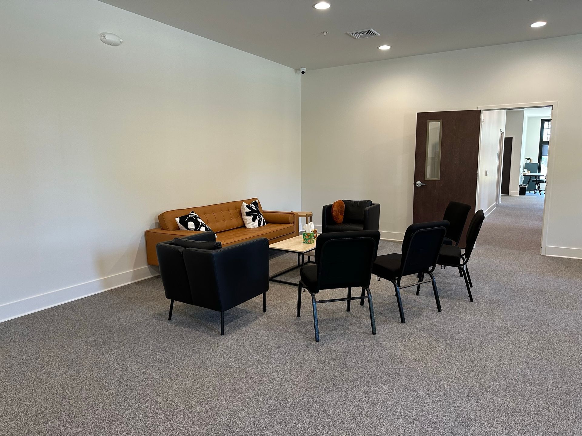 A living room with a couch , chairs , and a table.
