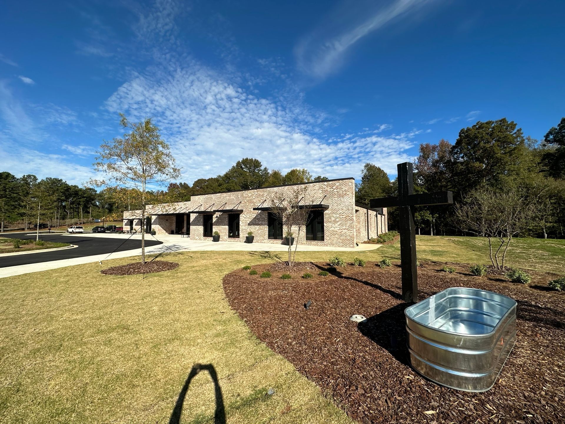 A metal tub is sitting in front of a stone building.
