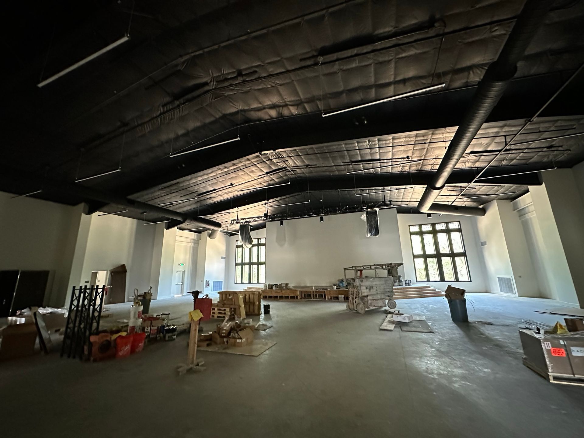 A large empty room with a black ceiling and a lot of boxes on the floor.