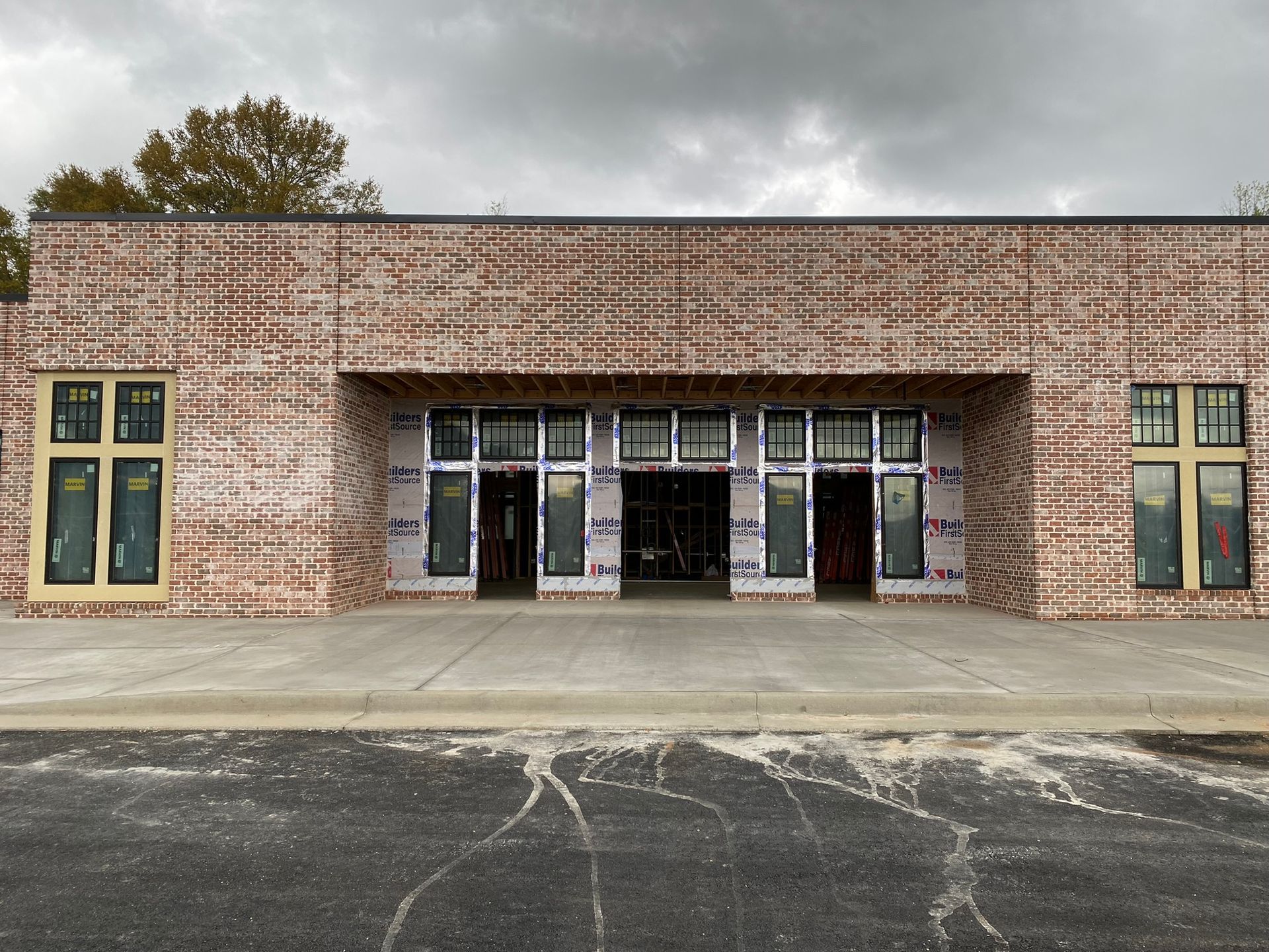 A large brick building with a lot of windows is under construction.