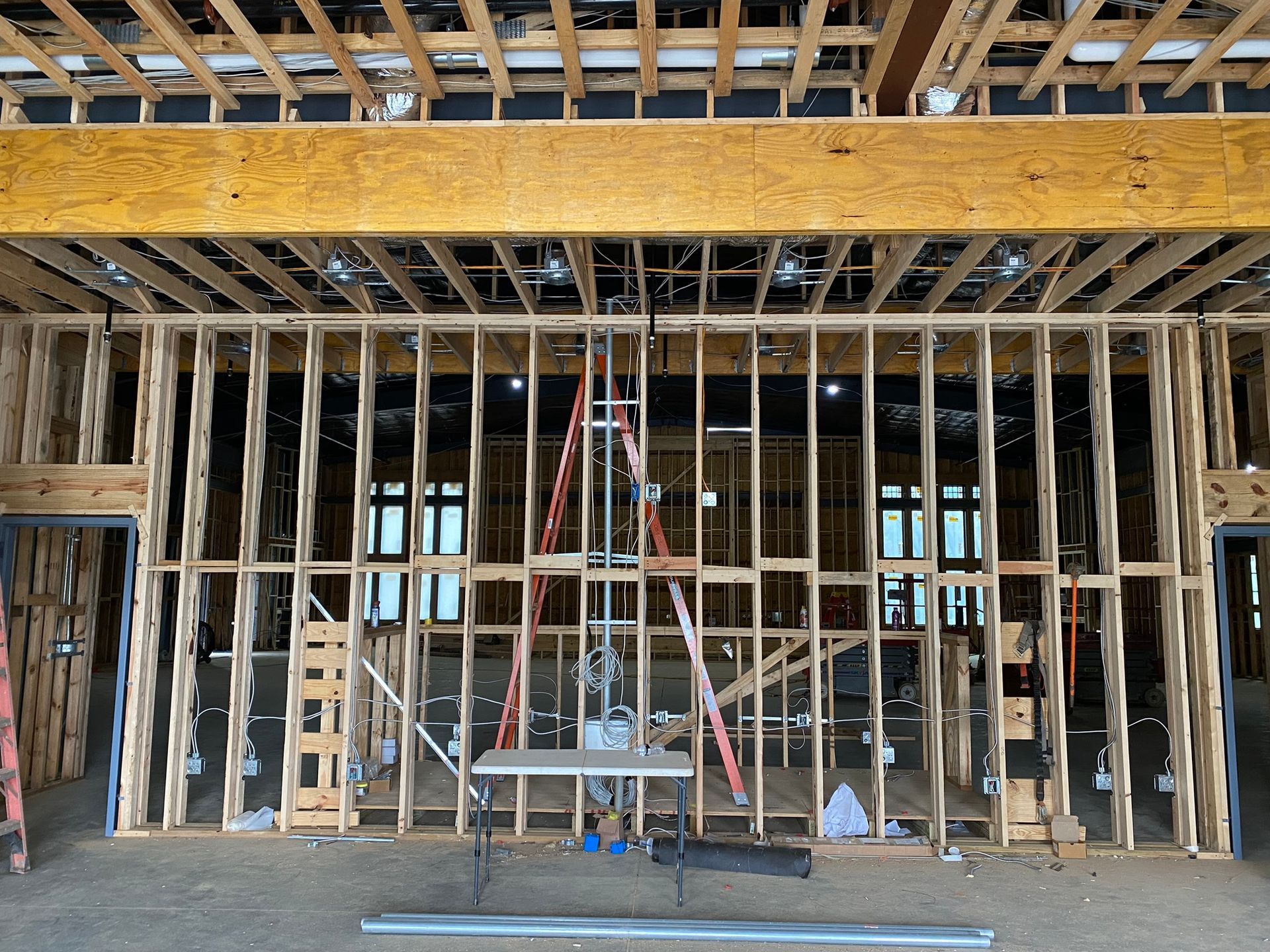 The inside of a building under construction with a table and ladder.