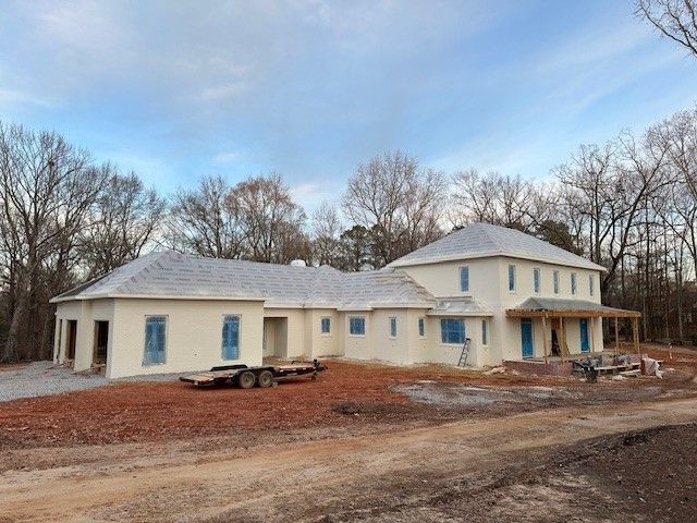 An aerial view of a new Hovey Precast office building with a blue roof surrounded by trees.
