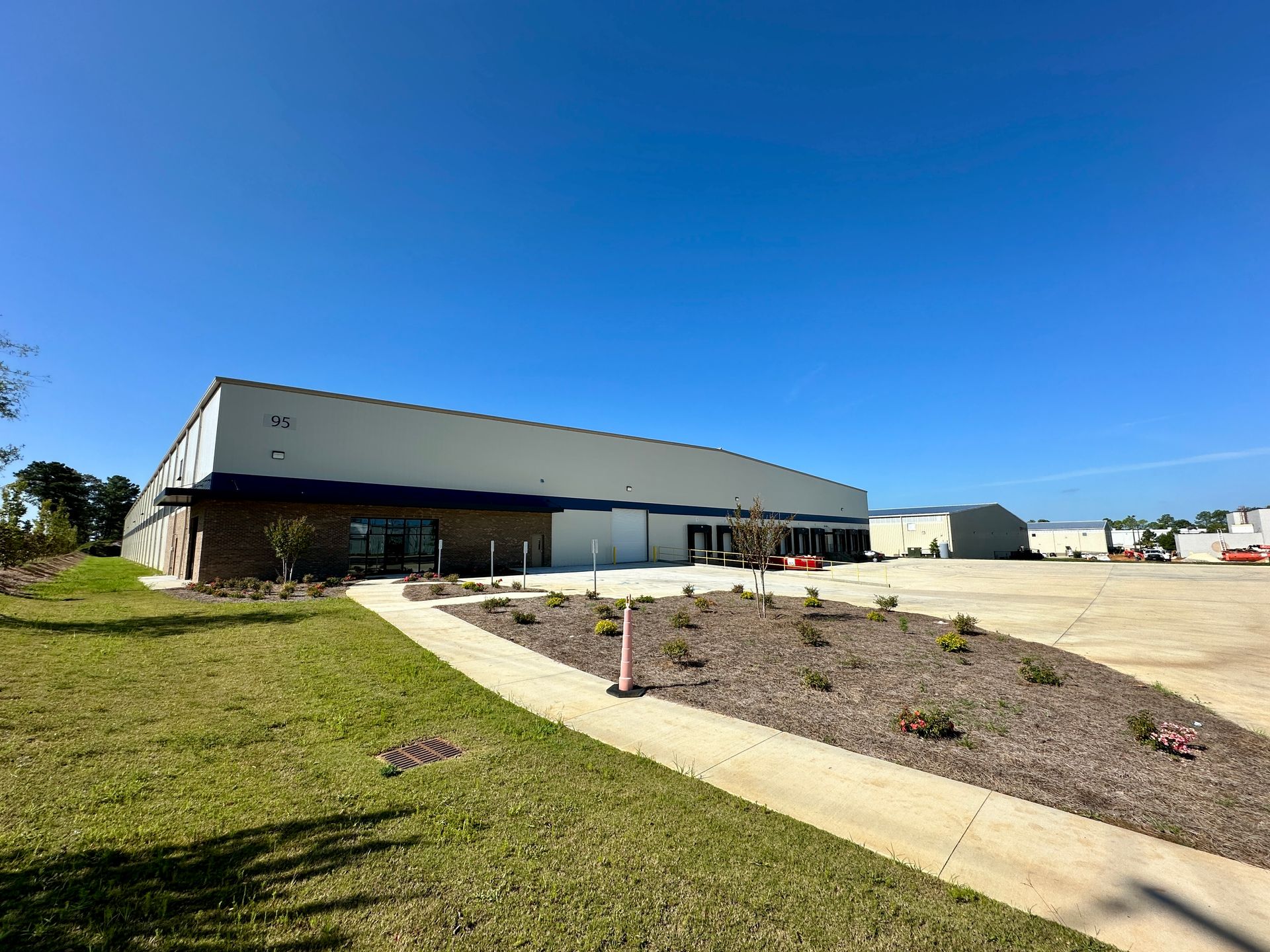 A large white building with a lot of grass in front of it.