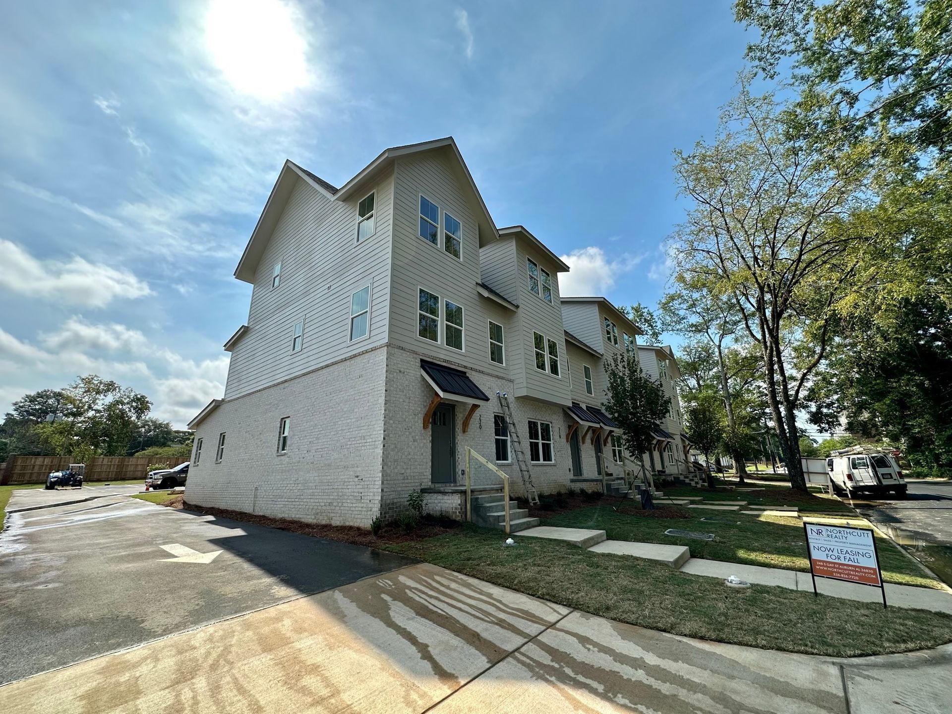 A large white building with a lot of windows is for sale.