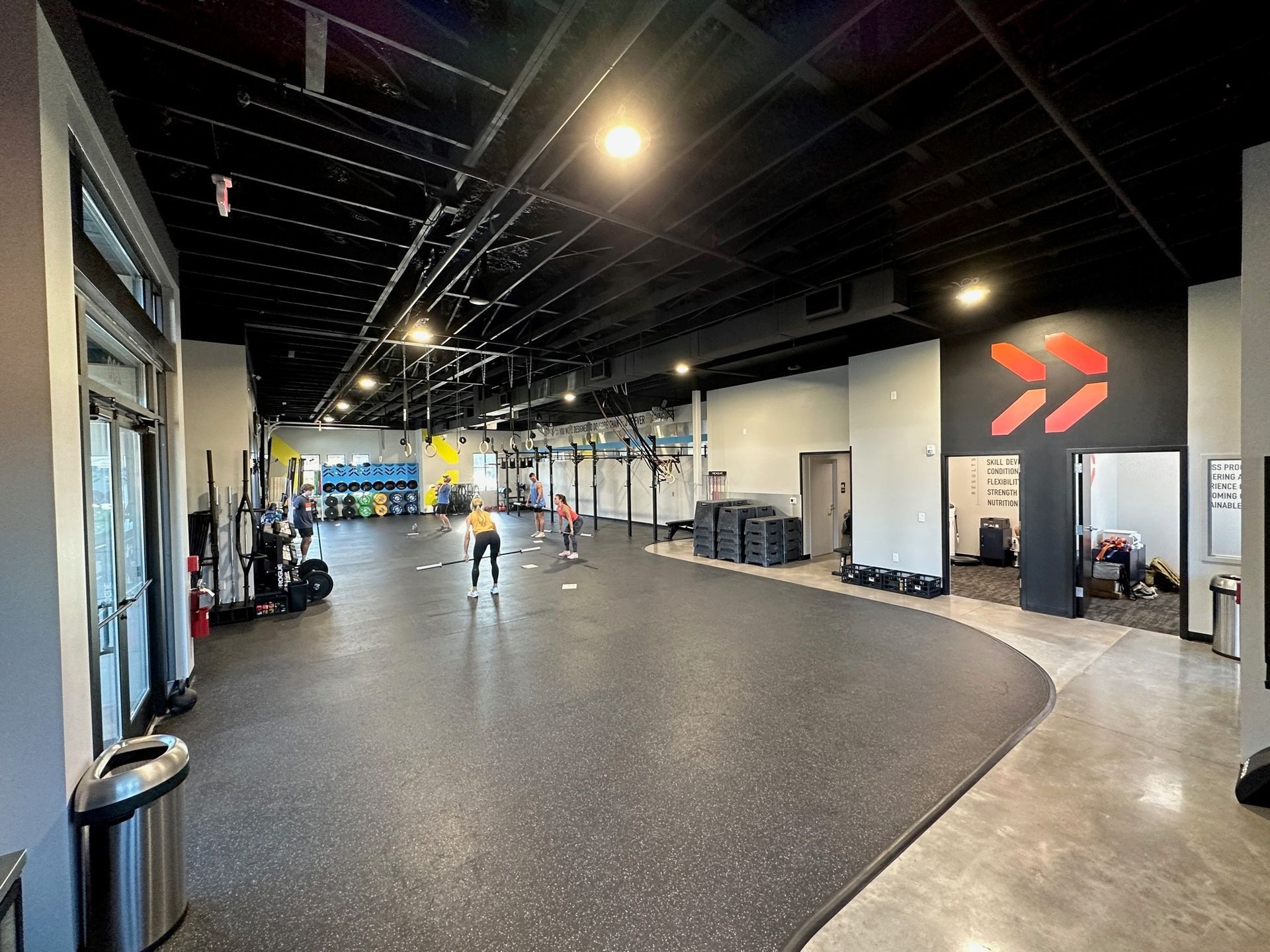 A large gym with a lot of equipment and people.