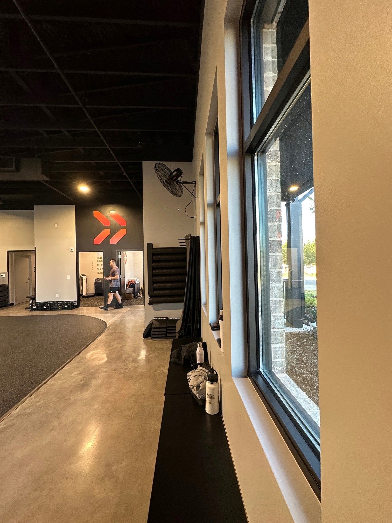 A gym with a lot of windows and a staircase in the background.
