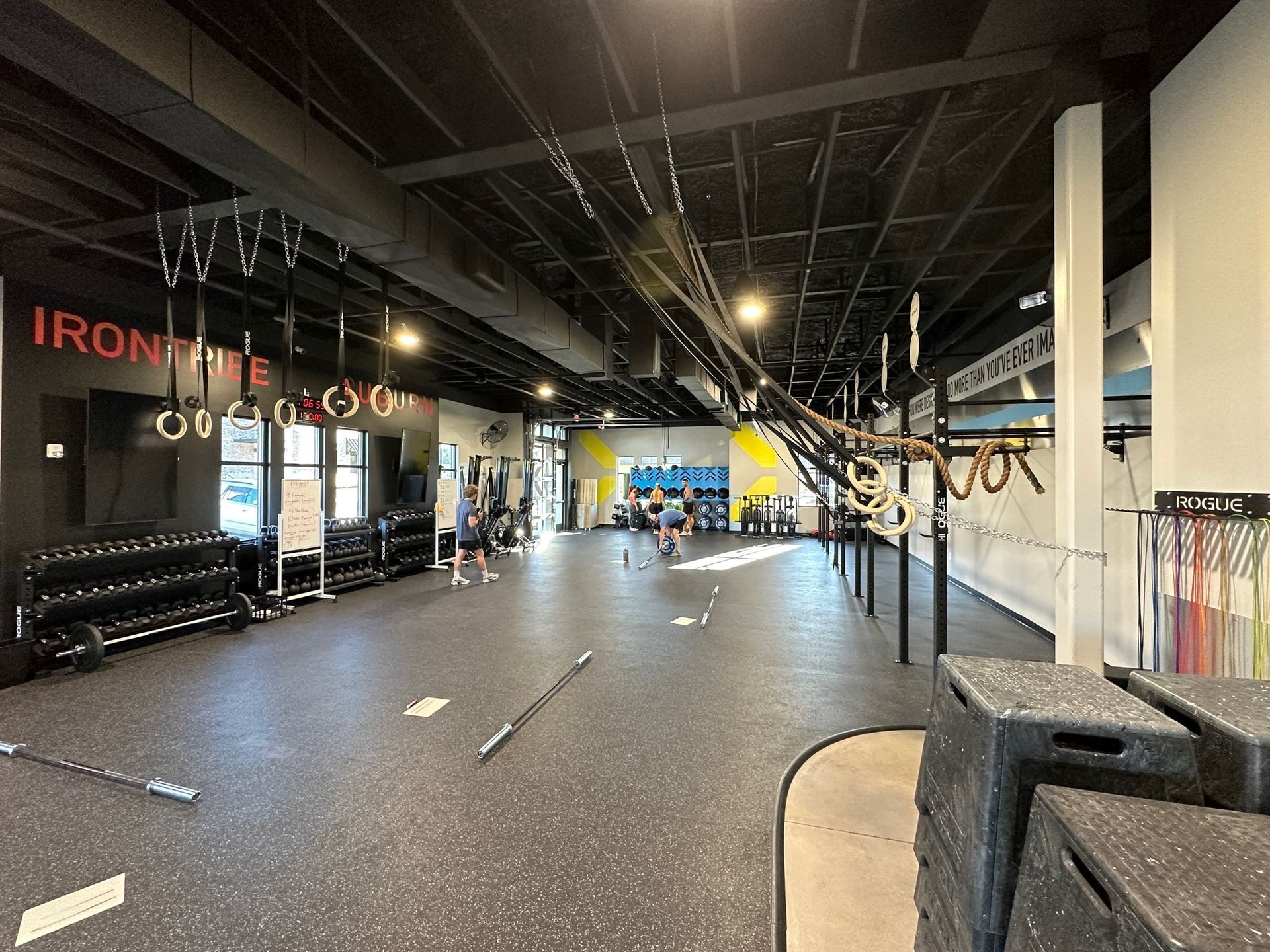 A large gym with a lot of equipment and people in it.