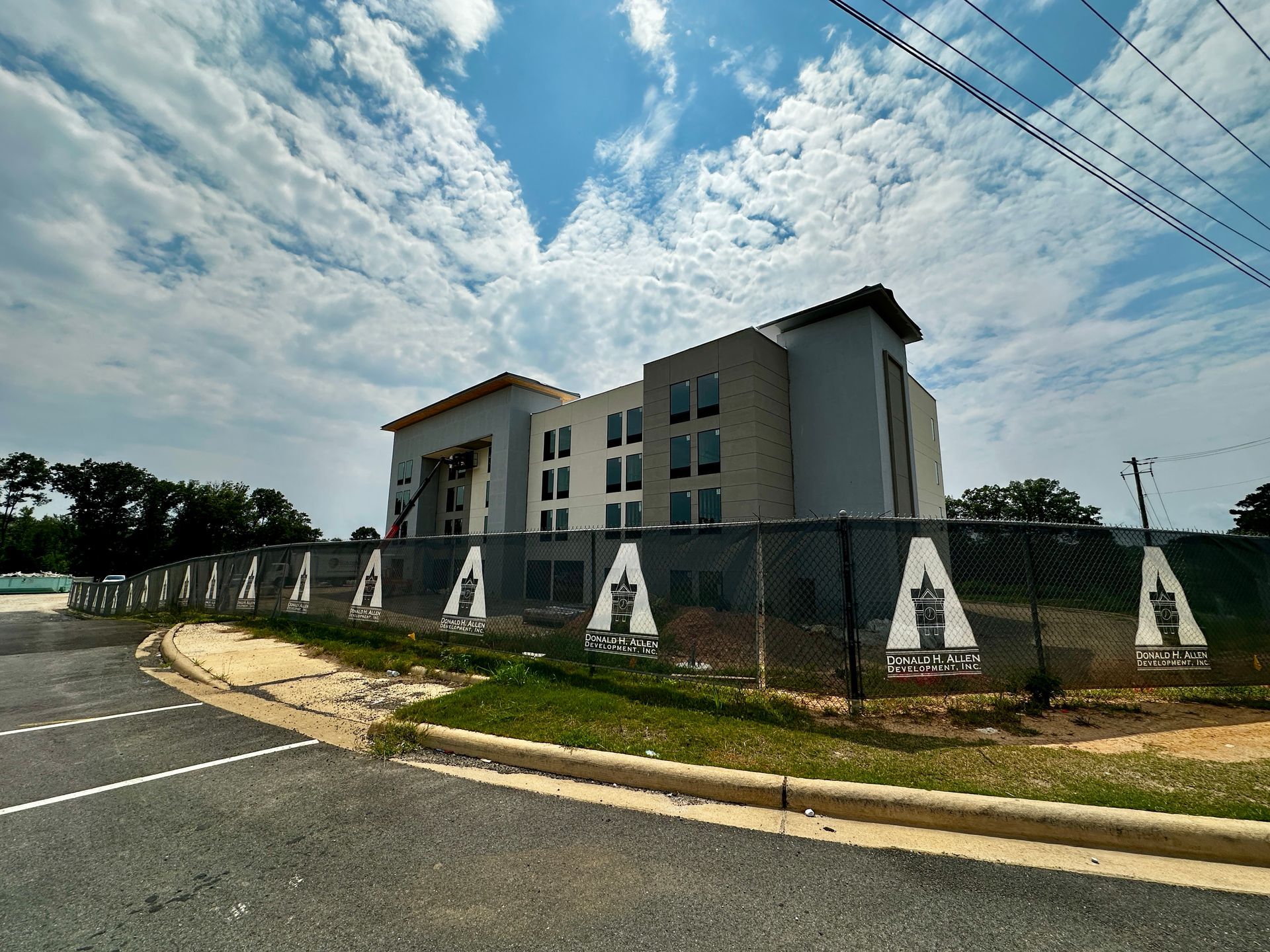 An aerial view of a new Hovey Precast office building with a blue roof surrounded by trees.