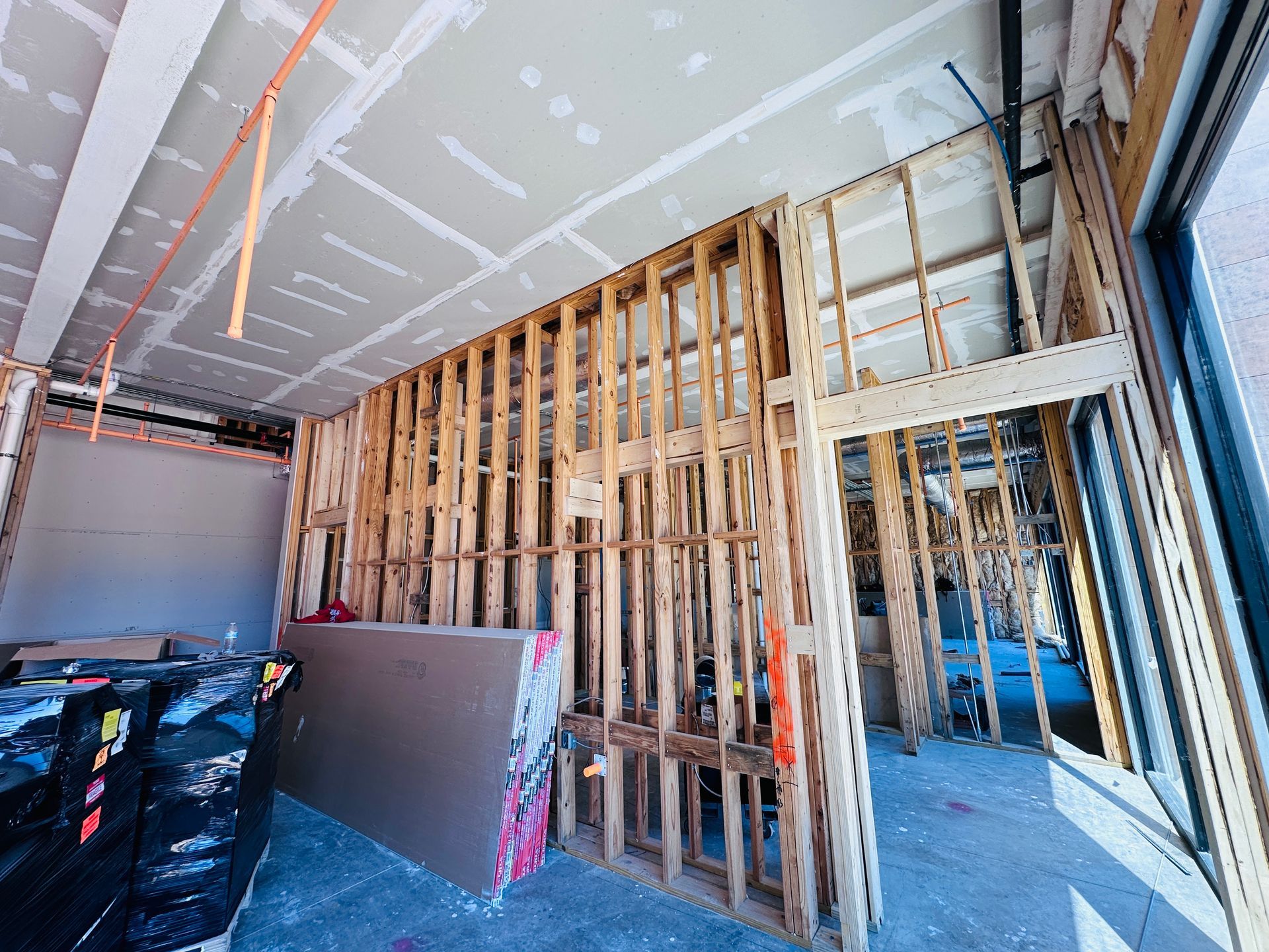Interior of a hotel construction with exposed wood framing, drywall, and construction materials.