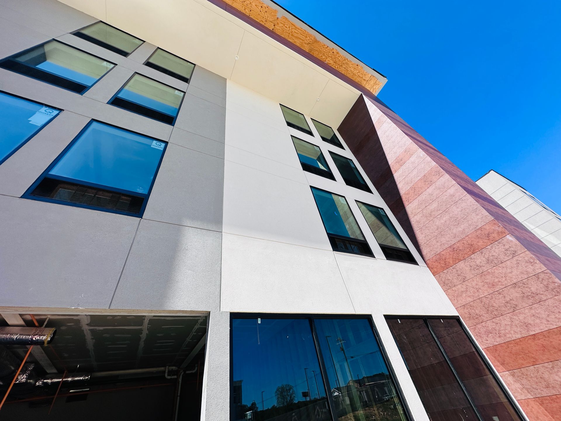 Modern building exterior with tall windows and a blue sky overhead