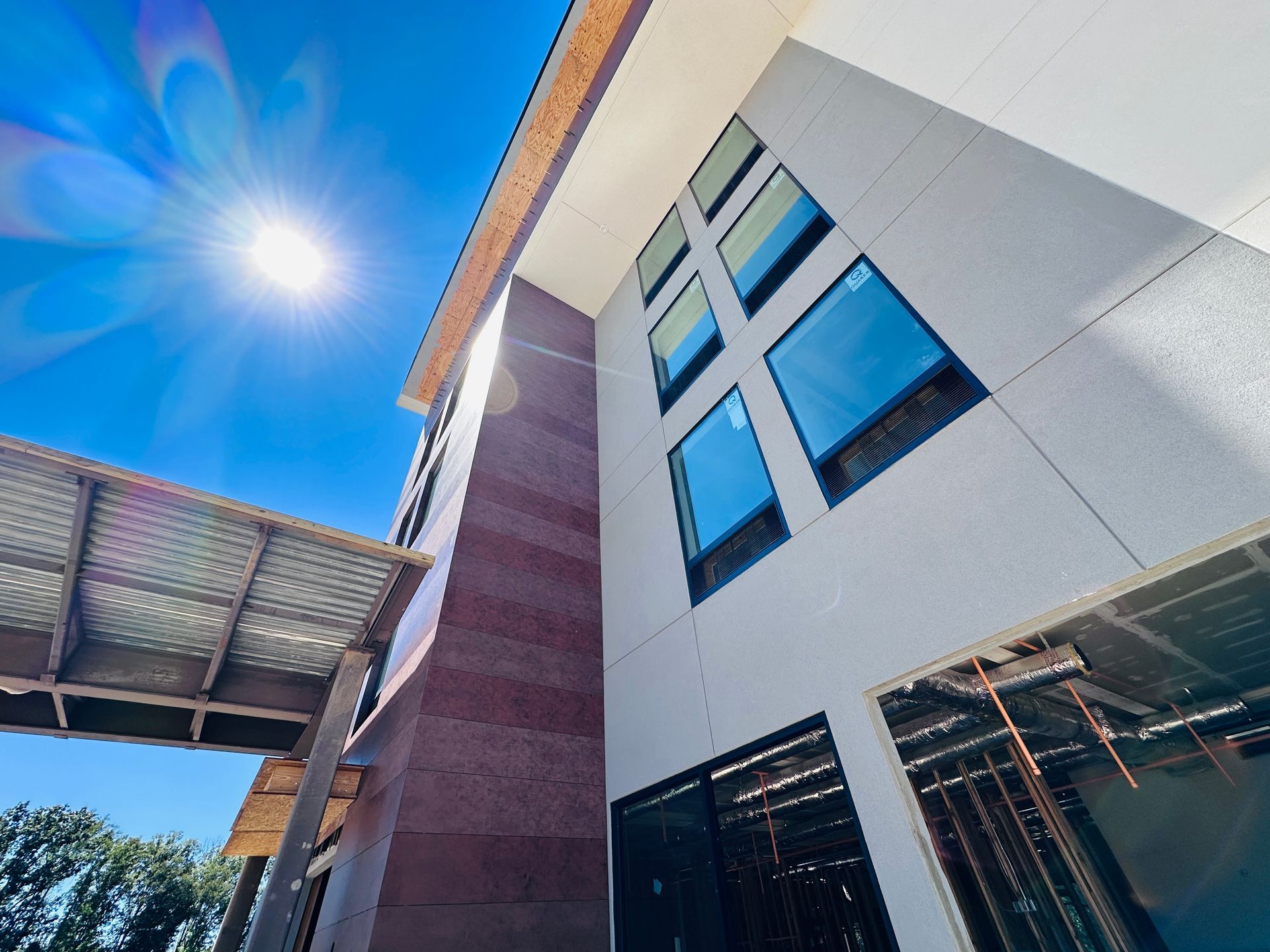 An aerial view of a new Hovey Precast office building with a blue roof surrounded by trees.
