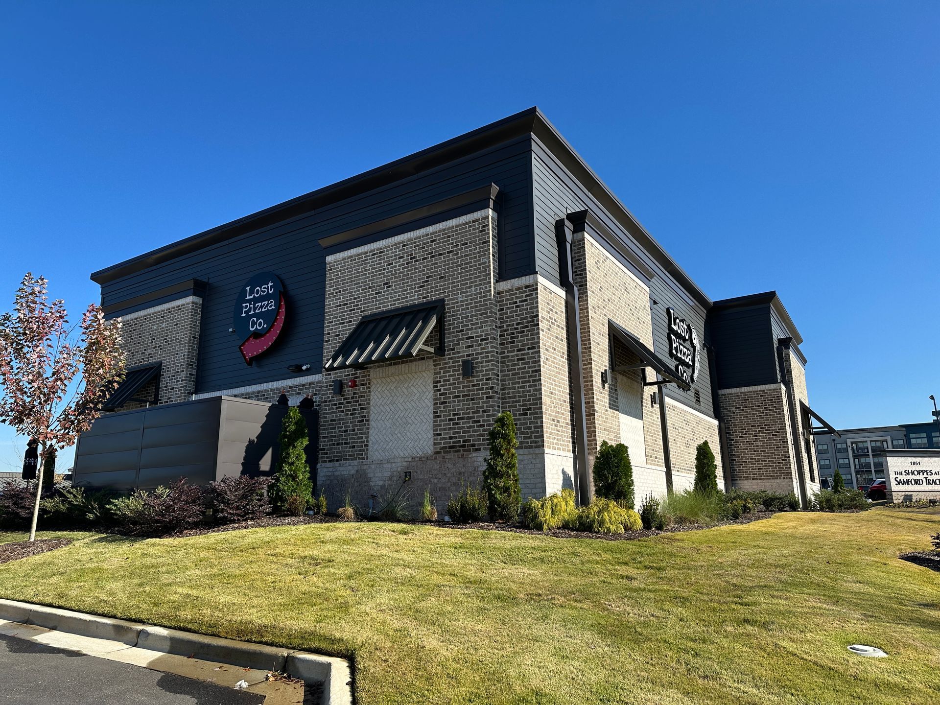Exterior view of a Chili's restaurant with brick and dark siding under a clear blue sky.
